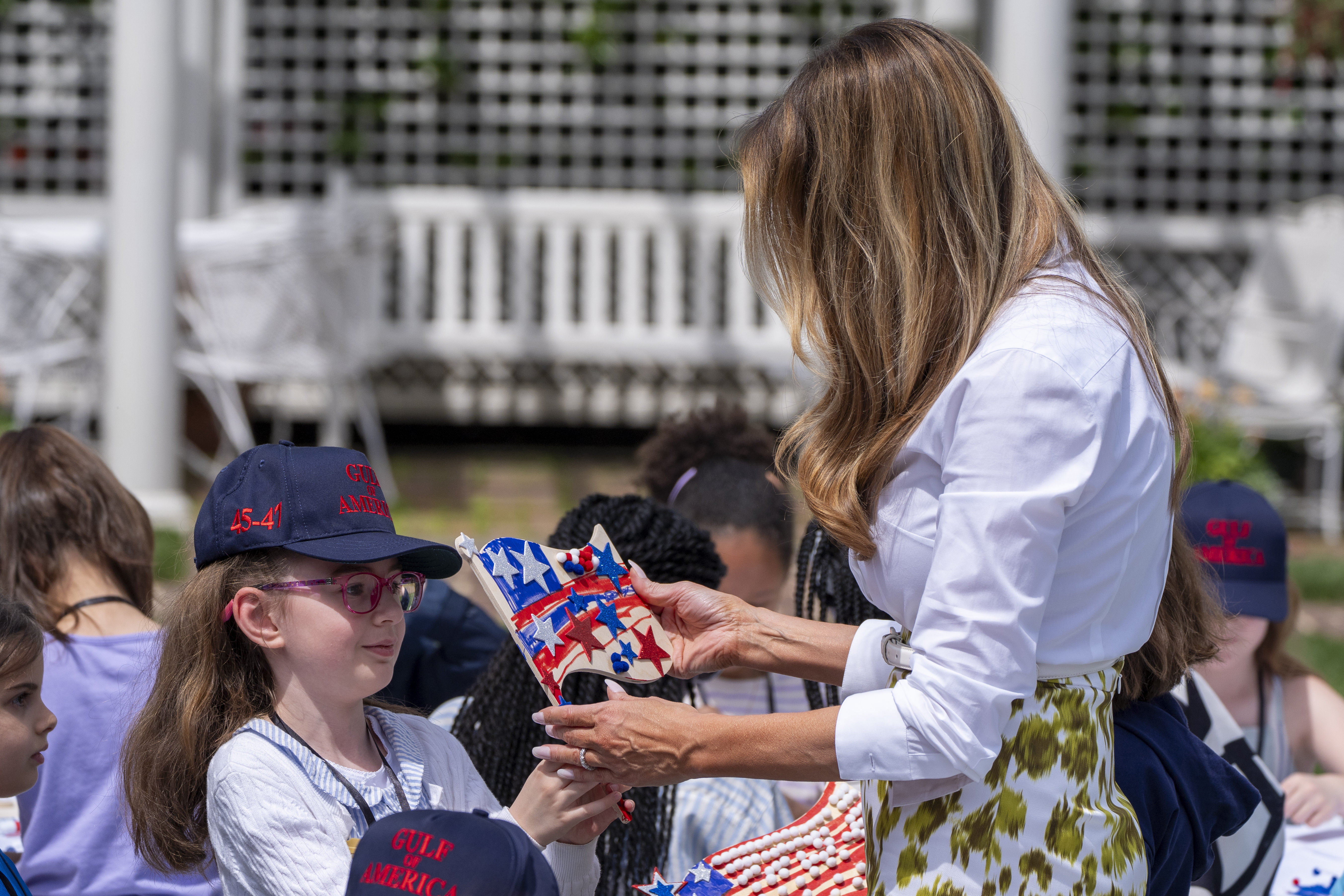 First lady Melania Trump looks at a decorated flag as she participates in flag decorating during a Take Our Child to Work Day event in the Jacqueline Kennedy Garden at the White House, Tuesday, May 20, 2025, in Washington. (AP Photo/Alex Brandon)