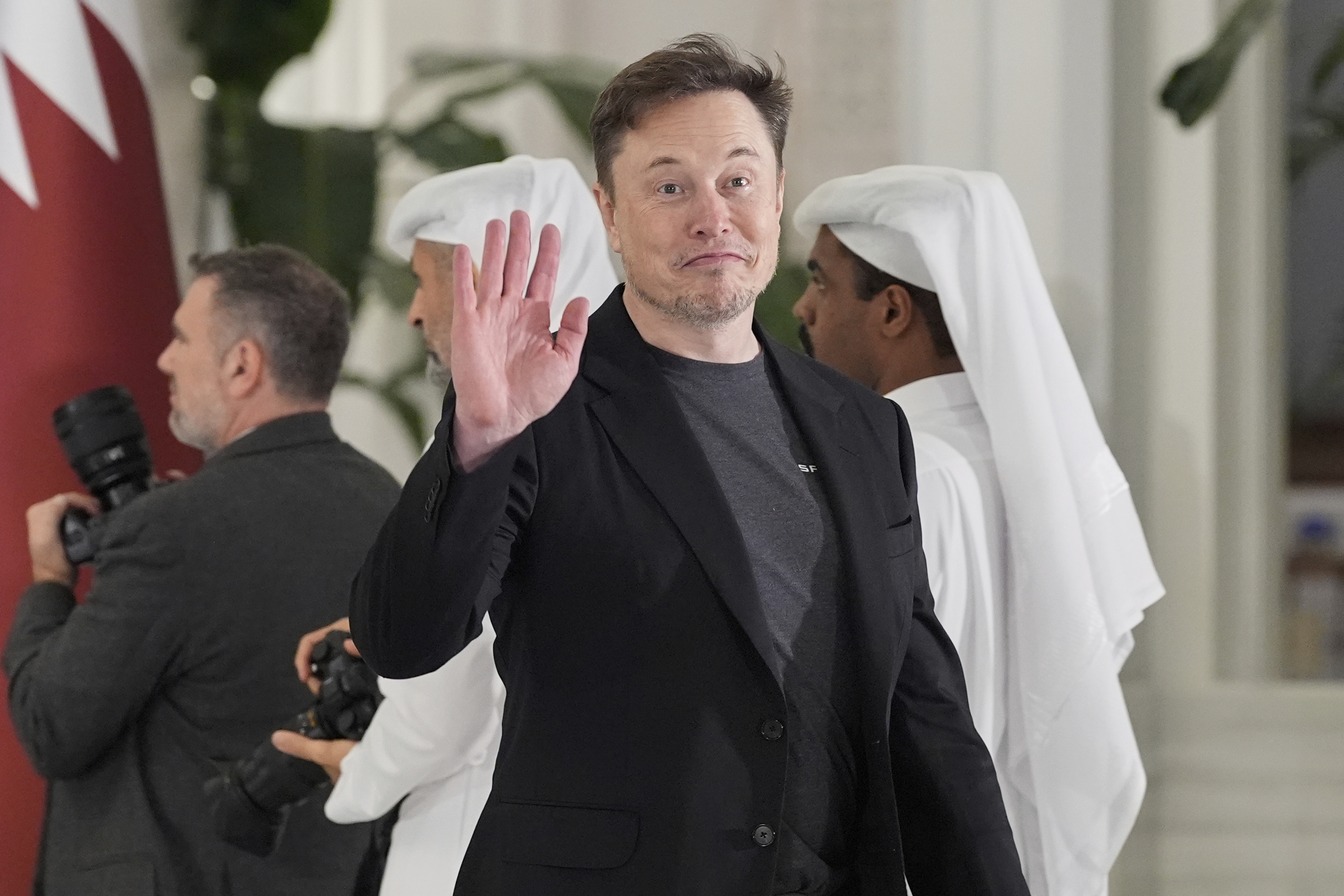 Elon Musk gestures as he arrives for a state dinner hosted by Qatar's Emir Sheikh Tamim bin Hamad Al Thani in honor of President Donald Trump at Lusail Palace in Doha, Qatar, Wednesday, May 14, 2025. (AP Photo/Alex Brandon)