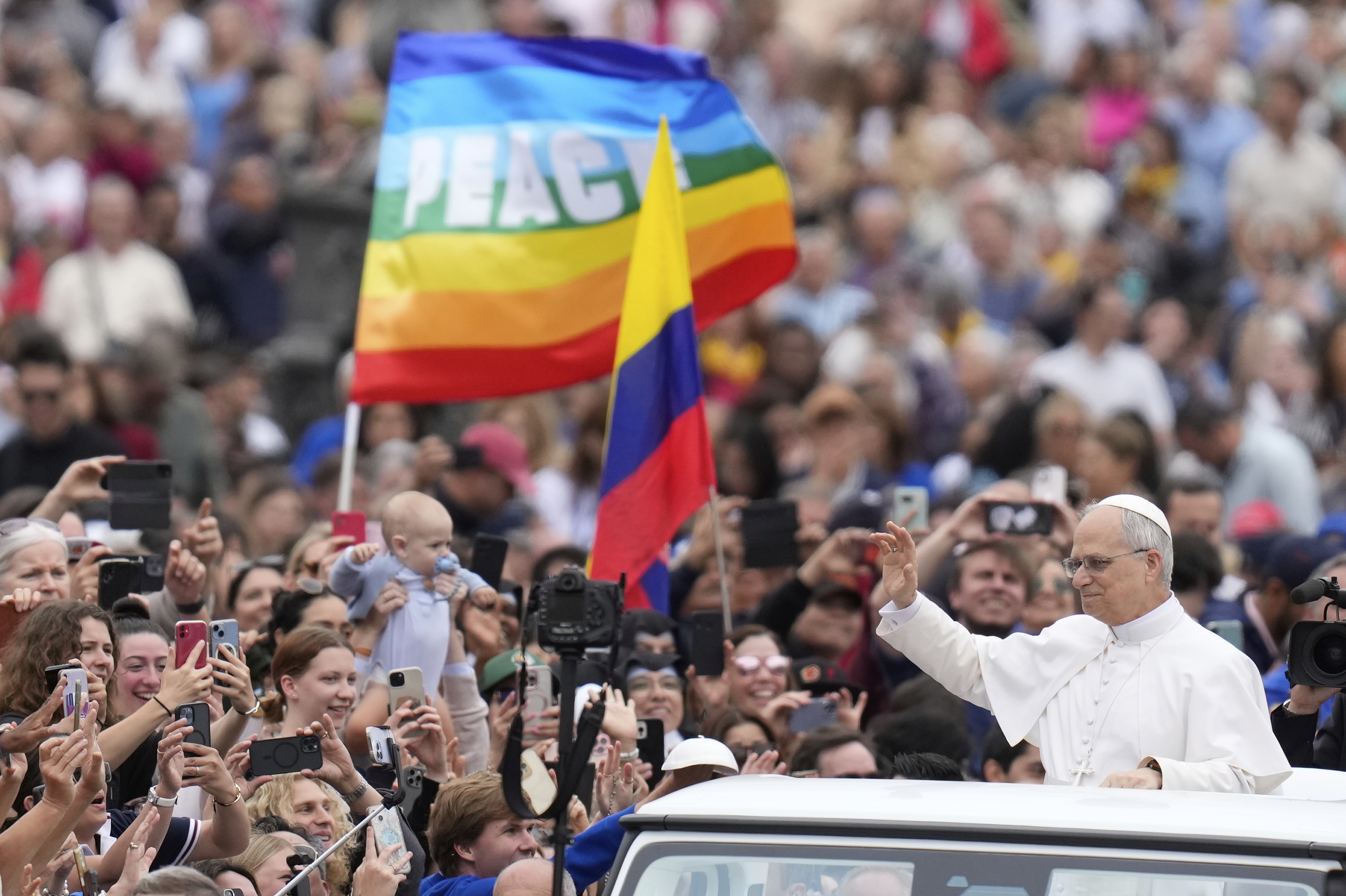 Pope Leo XIV waves as he arrives for his first weekly general audience in St. Peter's Square at The Vatican, Wednesday, May 21, 2025. (AP Photo/Gregorio Borgia)
