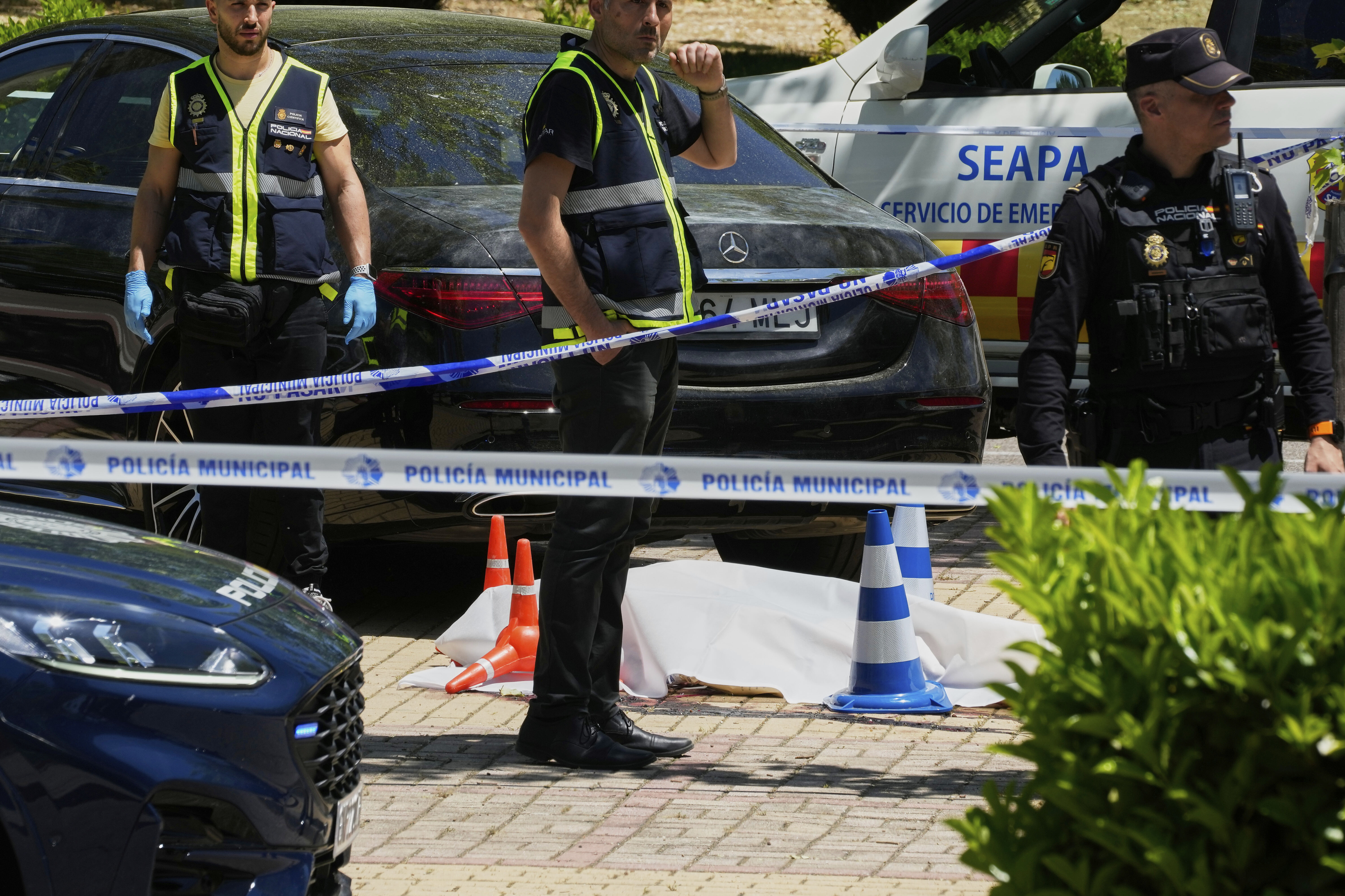 Members of the judicial police at the scene after Andrii Portnov, an adviser to former Ukrainian president Viktor Yanukovych was shot, outside a school in Madrid, Spain, Wednesday, May 21, 2025. (AP Photo/Paul White)