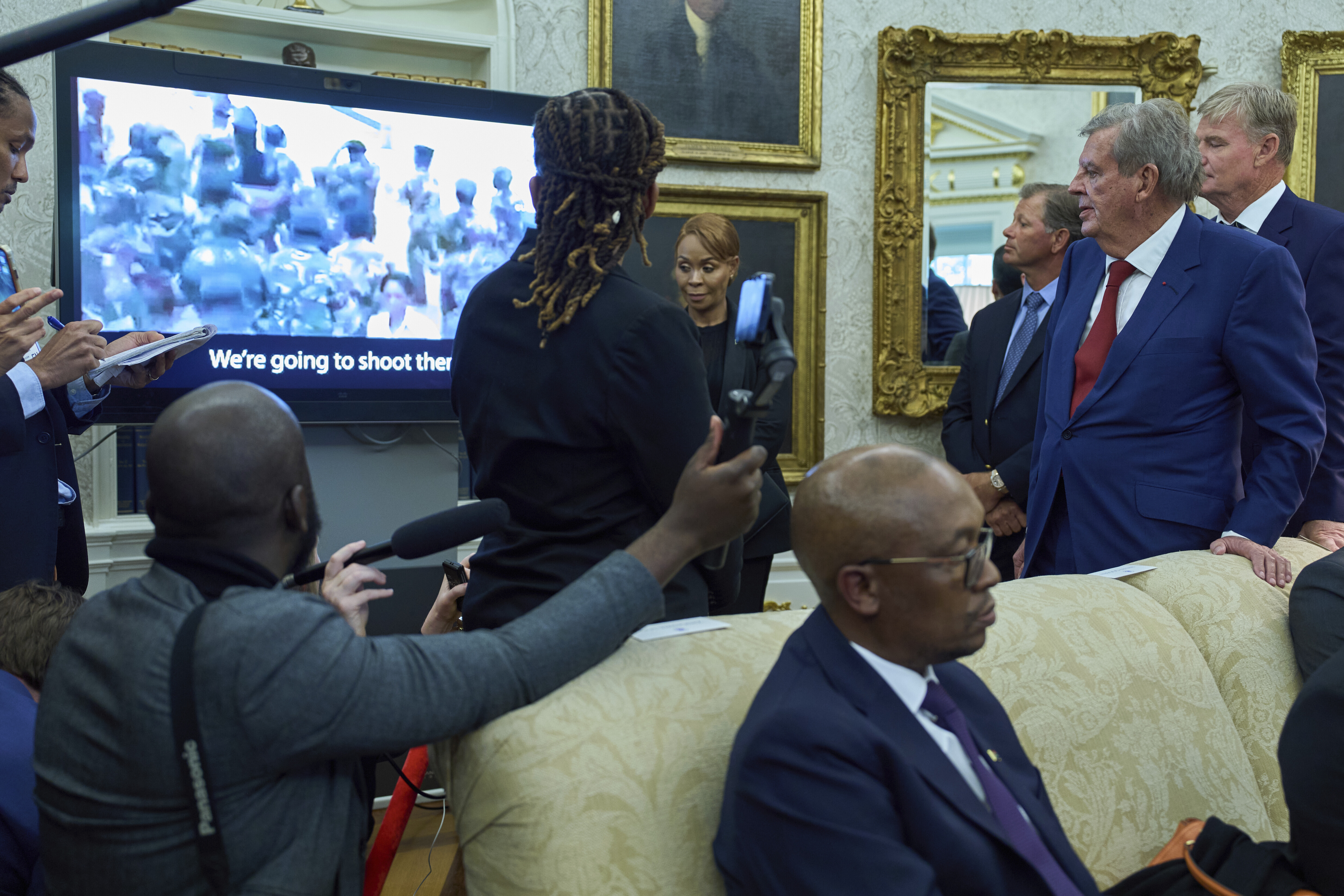 South African businessman Johann Rupert, standing right, watches a video during a meeting between President Donald Trump and South African President Cyril Ramaphosa in the Oval Office of the White House, Wednesday, May 21, 2025, in Washington. (AP Photo/Evan Vucci)