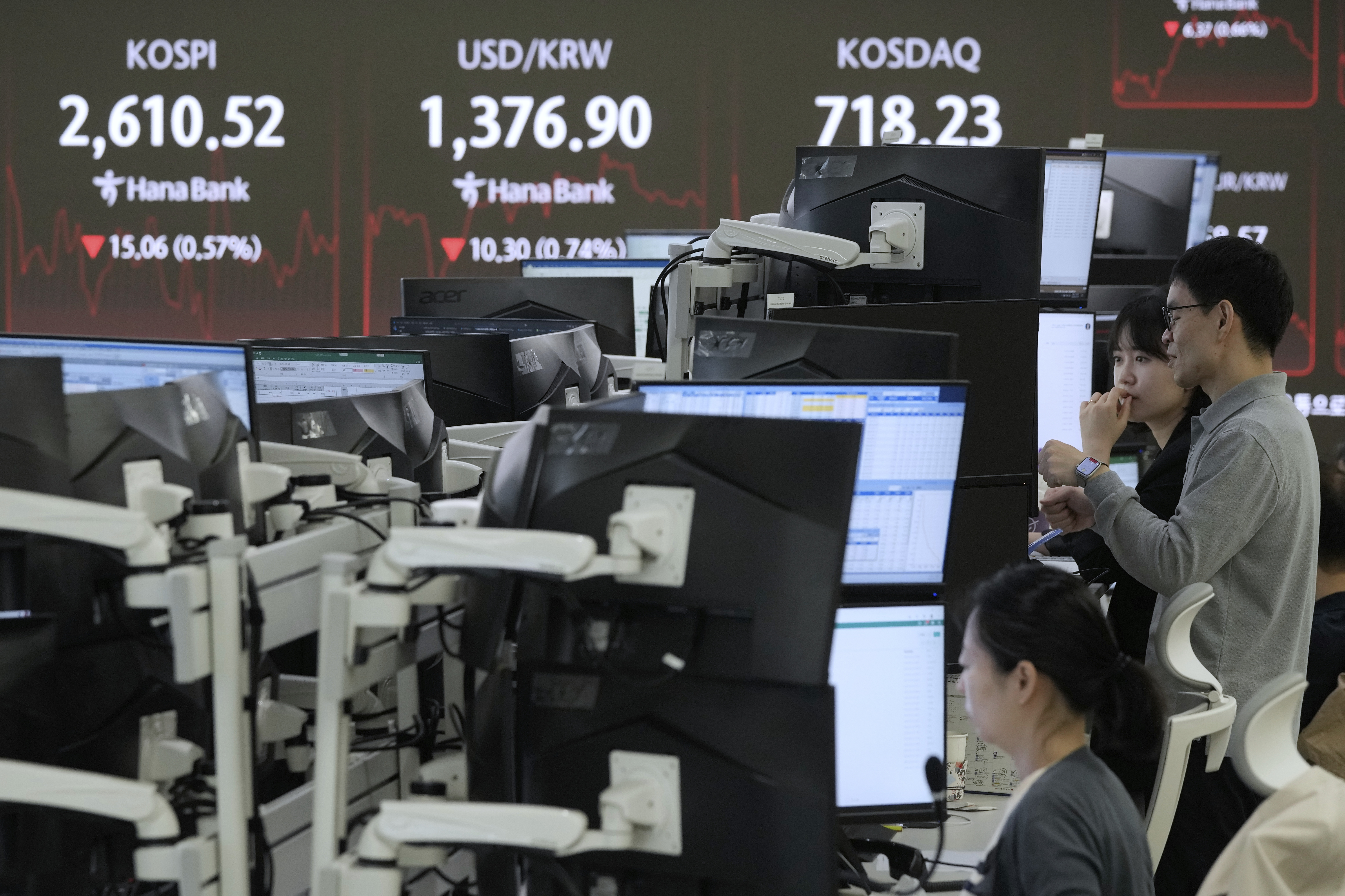 Currency traders watch monitors near a screen showing the Korea Composite Stock Price Index (KOSPI), top left, and the foreign exchange rate between U.S. dollar and South Korean won, top center, at the foreign exchange dealing room of the KEB Hana Bank headquarters in Seoul, South Korea, Thursday, May 22, 2025. (AP Photo/Ahn Young-joon)