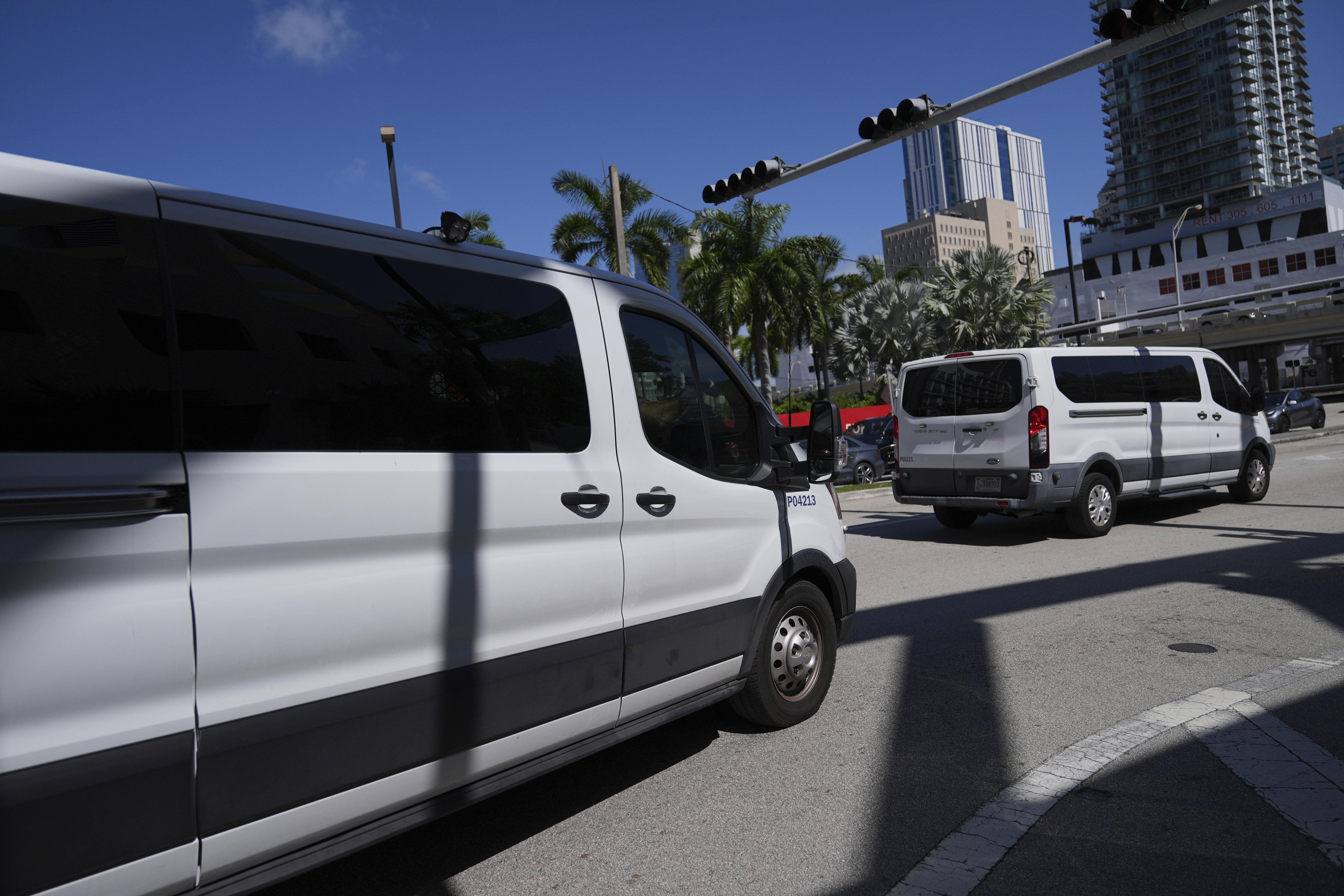 Department of Homeland Security vans leave carrying people detained by U.S. Immigration and Customs Enforcement agents at the Miami Immigration Court in Miami, on Wednesday, May 21, 2025. (AP Photo/Rebecca Blackwell)