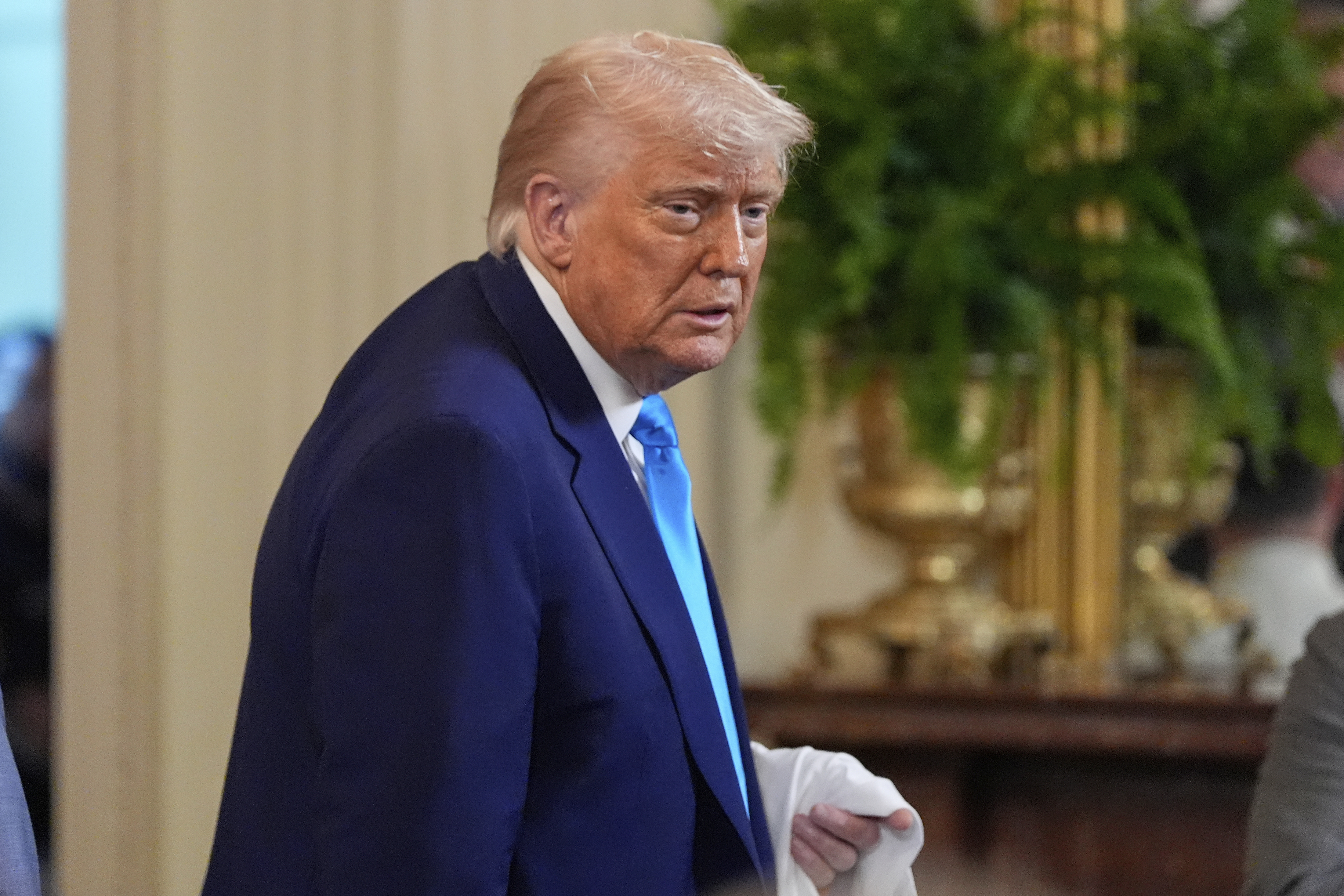 President Donald Trump holds a jersey as he departs after hosting the 2025 NCAA Champion, University of Florida men's basketball team in the East Room of the White House, Wednesday, May 21, 2025, in Washington. (AP Photo/Julia Demaree Nikhinson)