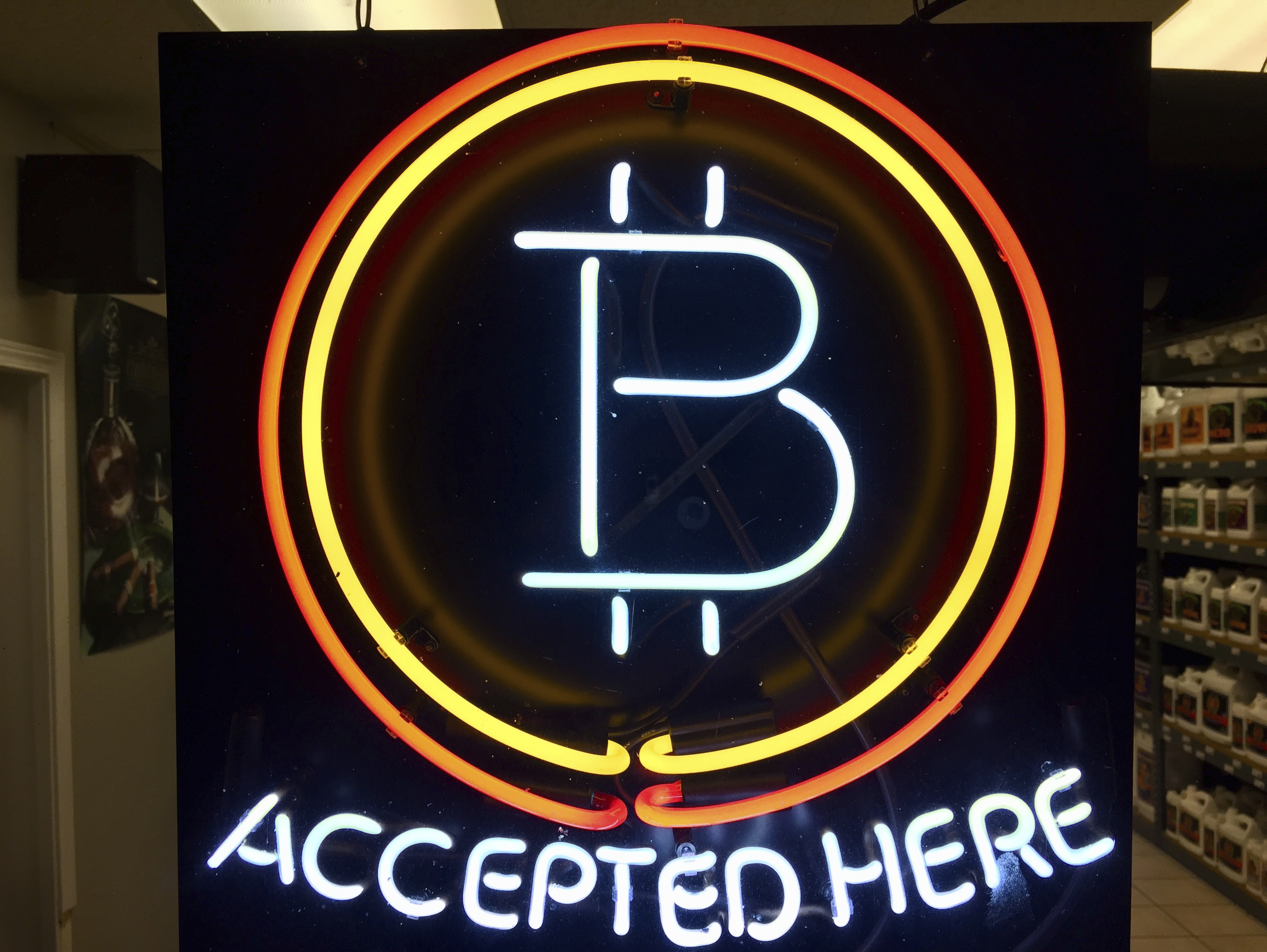 FILE - A neon sign that alerts customers that the business accepts bitcoin as payment, hangs in the window of Healthy Harvest Indoor Gardening in Hillsboro, Ore., on Feb. 7, 2018. (AP Photo/Gillian Flaccus, File)