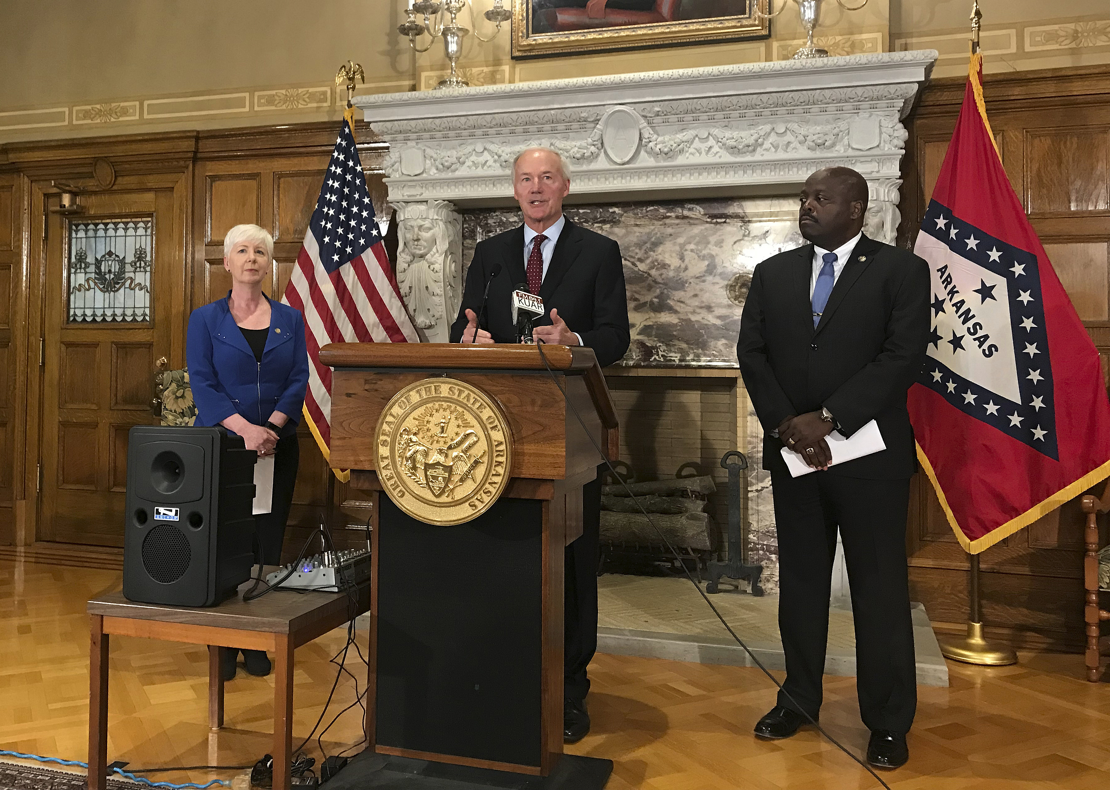 FILE - In this Sept. 12, 2018, file photo, Arkansas Gov. Asa Hutchinson, center, talks at a news conference at the State Capitol in Little Rock, Ark., about the state's work requirement for its expanded Medicaid program. (AP Photo/Andrew DeMillo, File)
