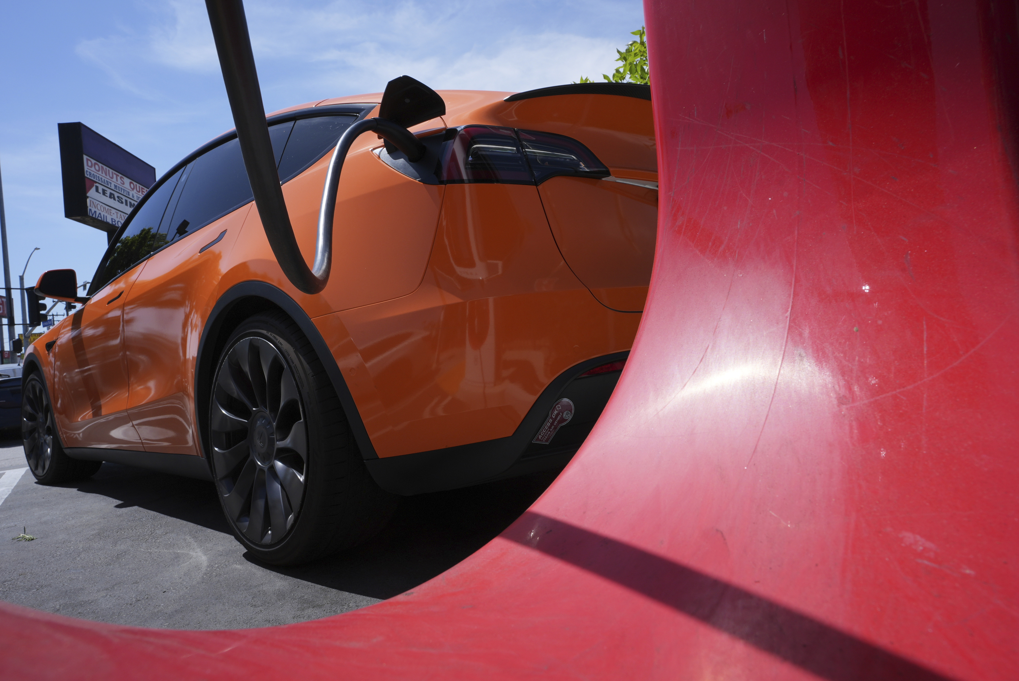 An electric vehicle is seen charging at a charging station Thursday, May 22, 2025, in Long Beach, Calif. (AP Photo/Damian Dovarganes)