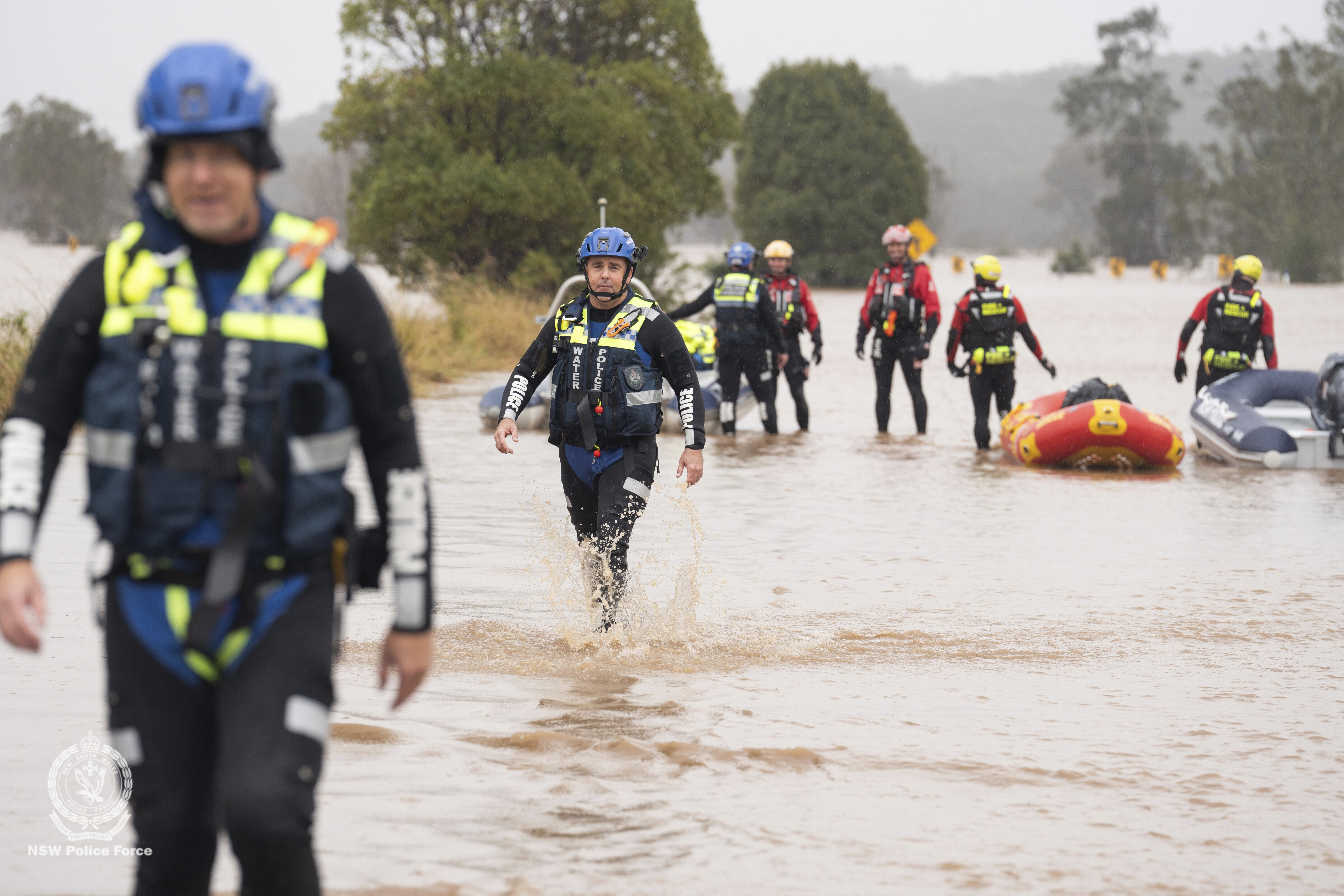 In this photo provided by the New South Wales Police, emergency workers wade through floodwaters as they prepare inflatable boats to effect rescues near Taree, Australia, Thursday, May 22, 2025. (NSW Police via AP)