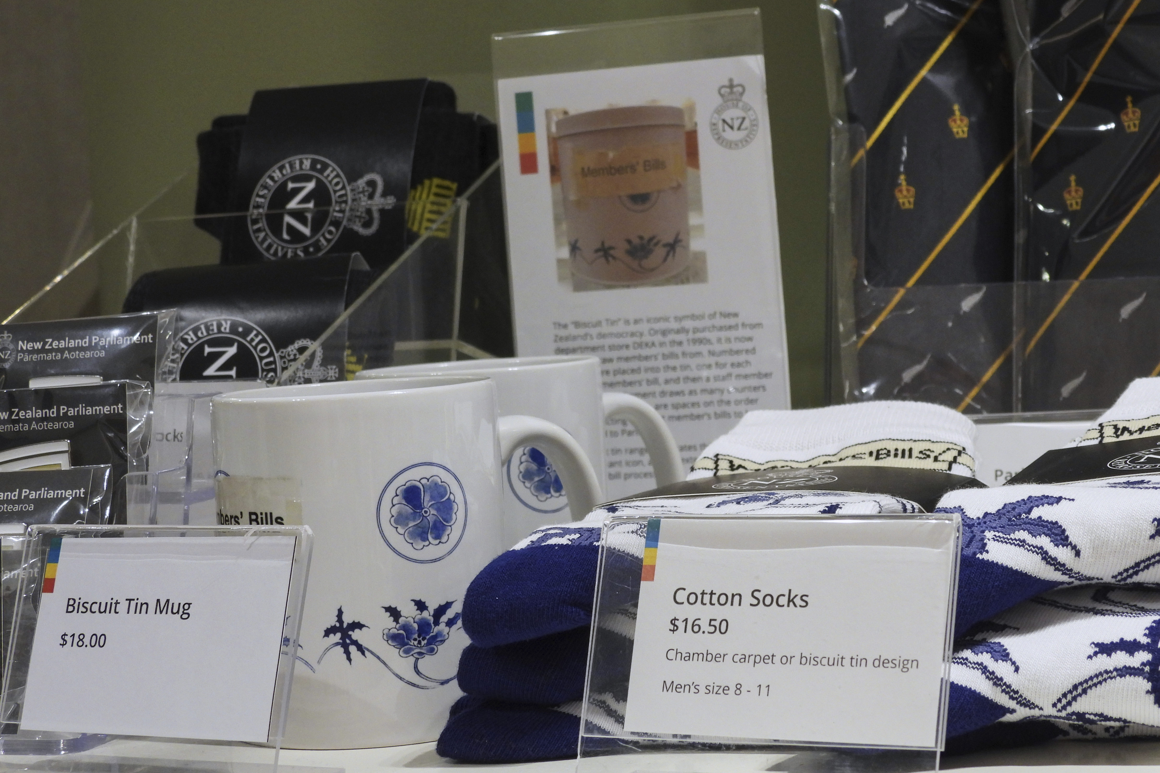 Socks are mugs printed with the biscuit tin pattern and label are seen for sale in the New Zealand Parliament gift shop in Wellington, New Zealand, Thursday, May 22, 2025. (AP Photo/Charlotte Graham-McLay)