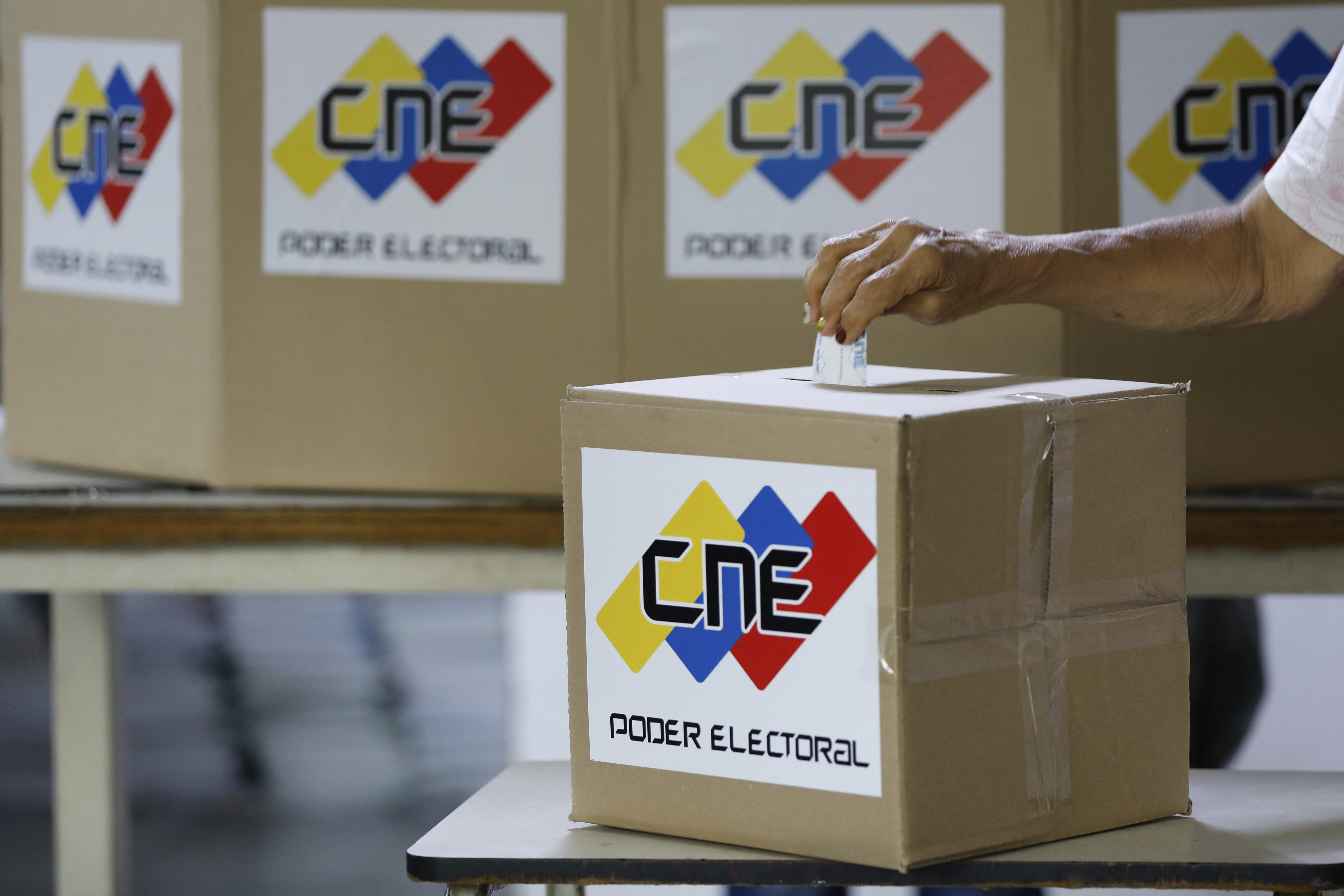 A woman casts a mock vote during a rehearsal for the upcoming regional election, in Caracas, Venezuela, Saturday, May 10, 2025. (AP Photo/Cristian Hernandez)
