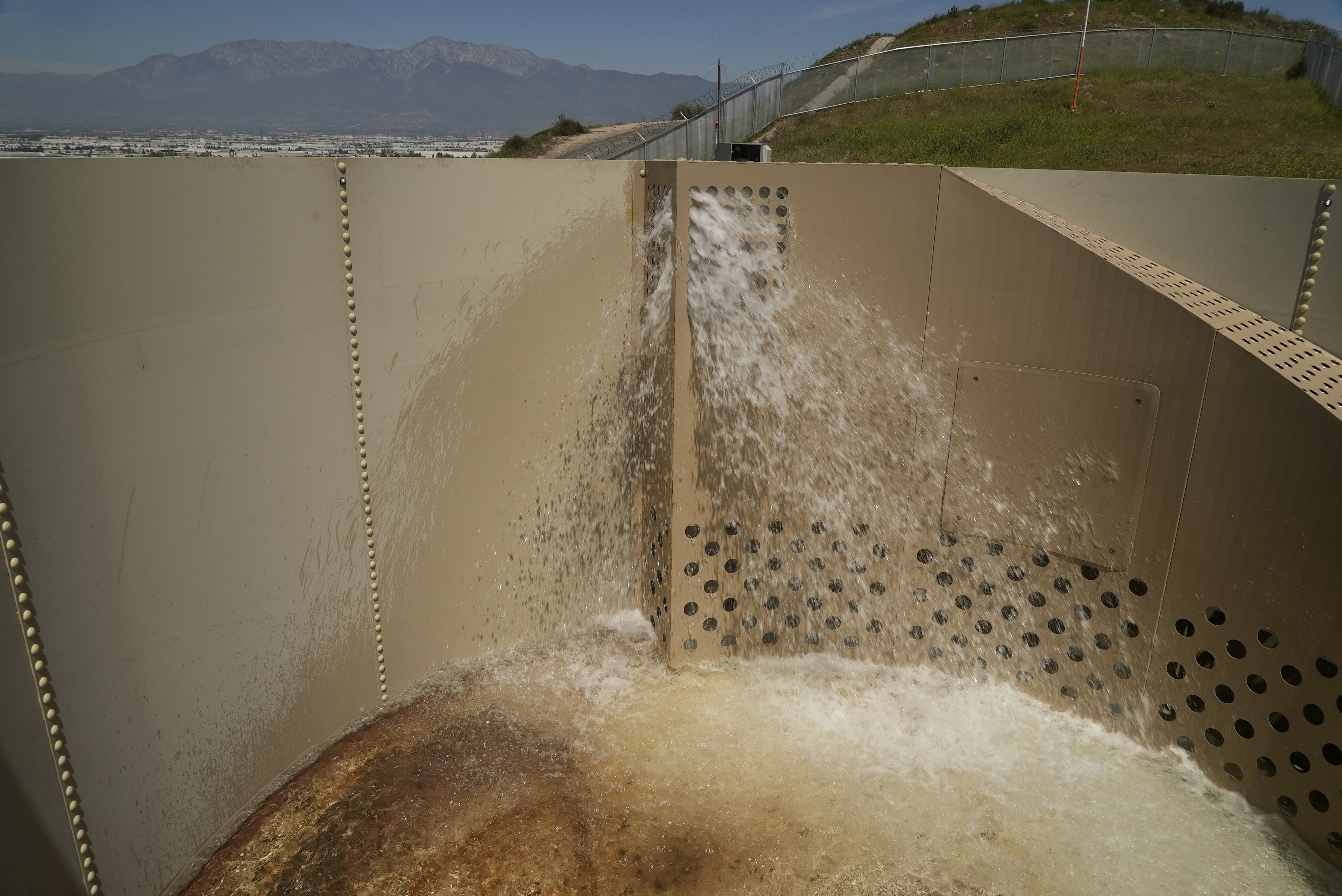 A Heli-Hydrant, a small, open tank that helicopters can rely on to get water faster for urban fires, fills with water during a demonstration Thursday, April 10, 2025, in Jurupa Valley, Calif. (AP Photo/Brittany Peterson)