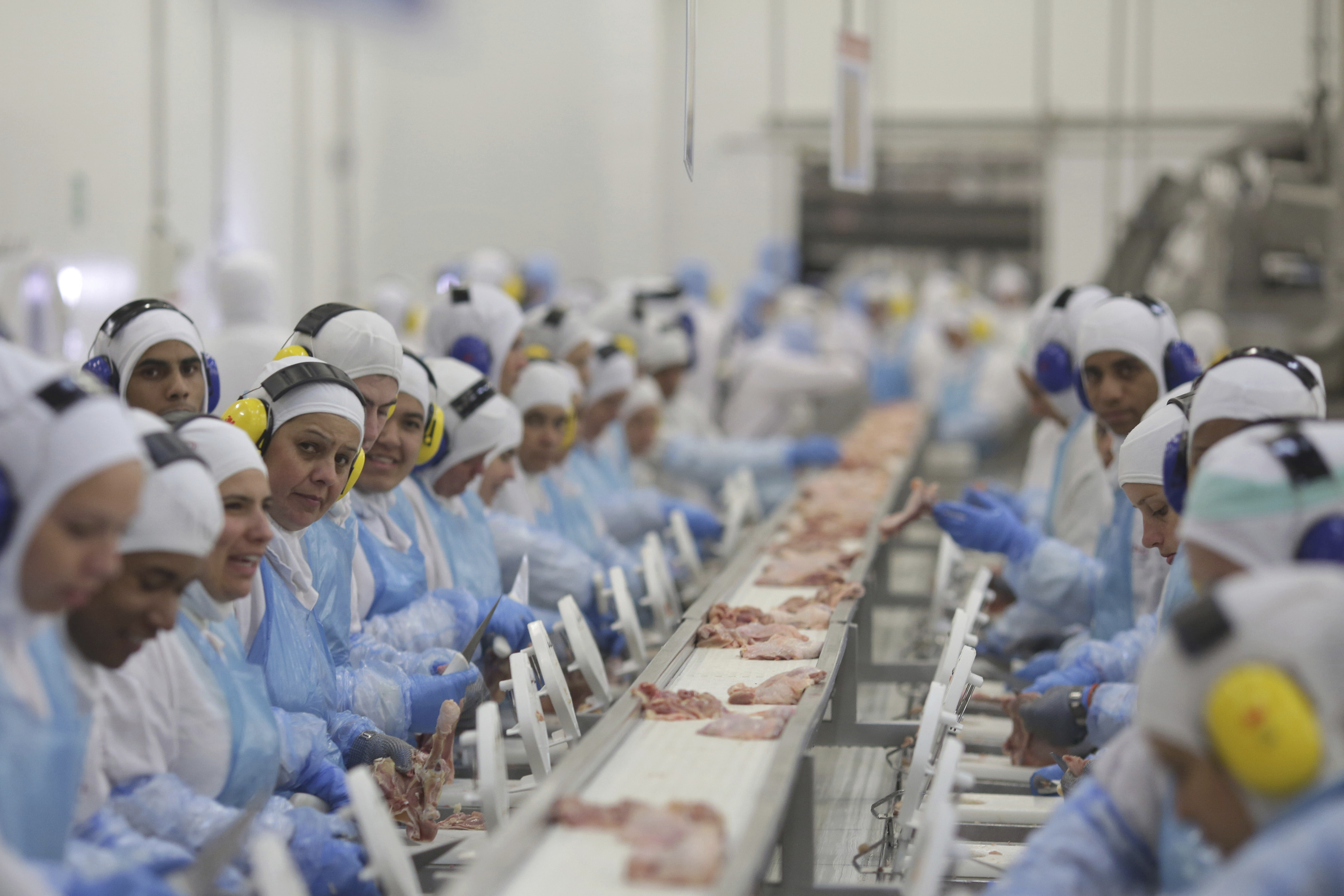 FILE - Workers prep poultry at the meatpacking company JBS, in Lapa, in the Brazilian state of Parana, March 21, 2017. (AP Photo/Eraldo Peres, File)