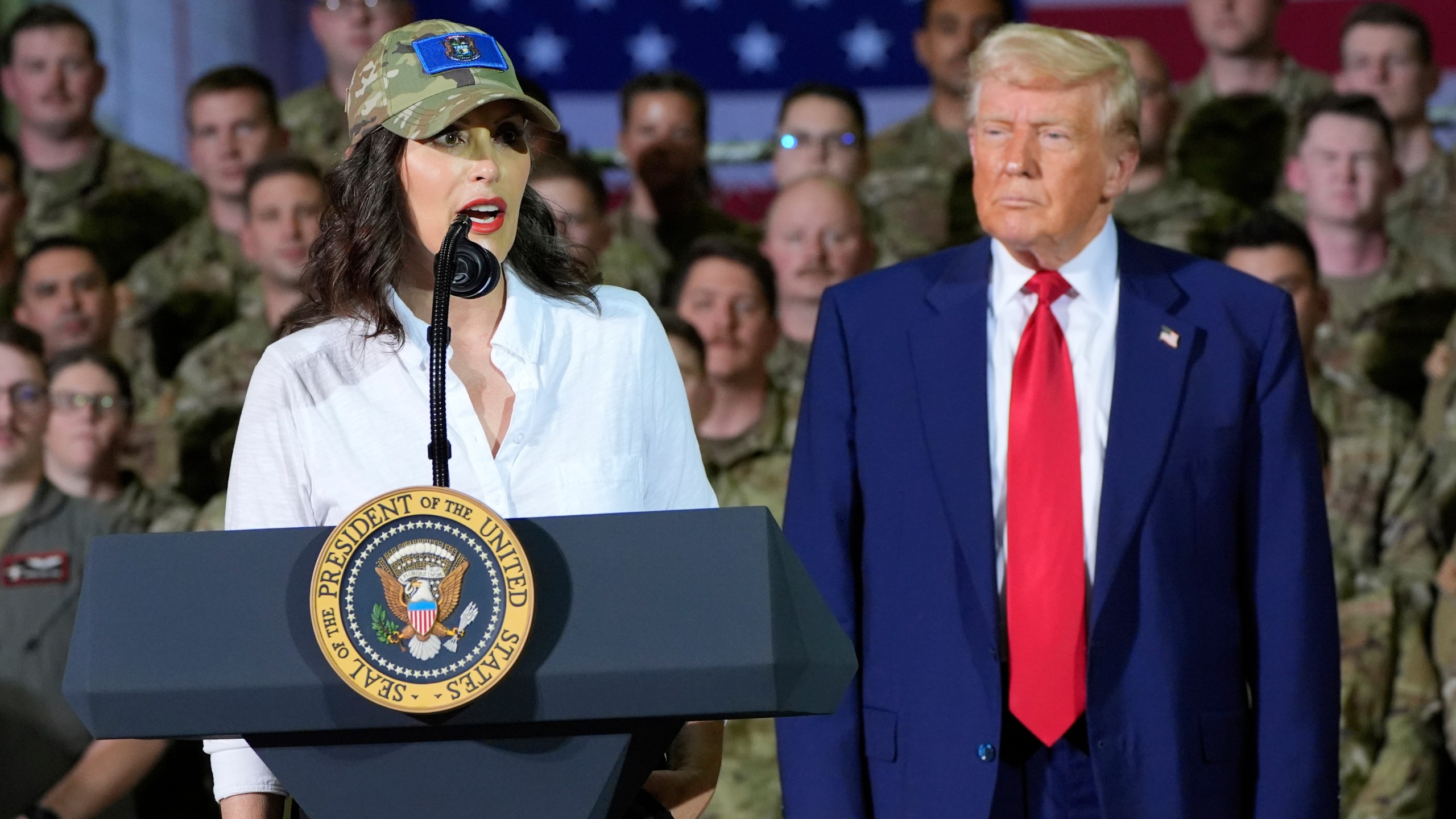 President Donald Trump listens as Michigan Gov. Gretchen Whitmer speaks to members of the Michigan National Guard at Selfridge Air National Guard Base, Tuesday, April 29, 2025, in Harrison Township, Mich. (AP Photo/Alex Brandon)