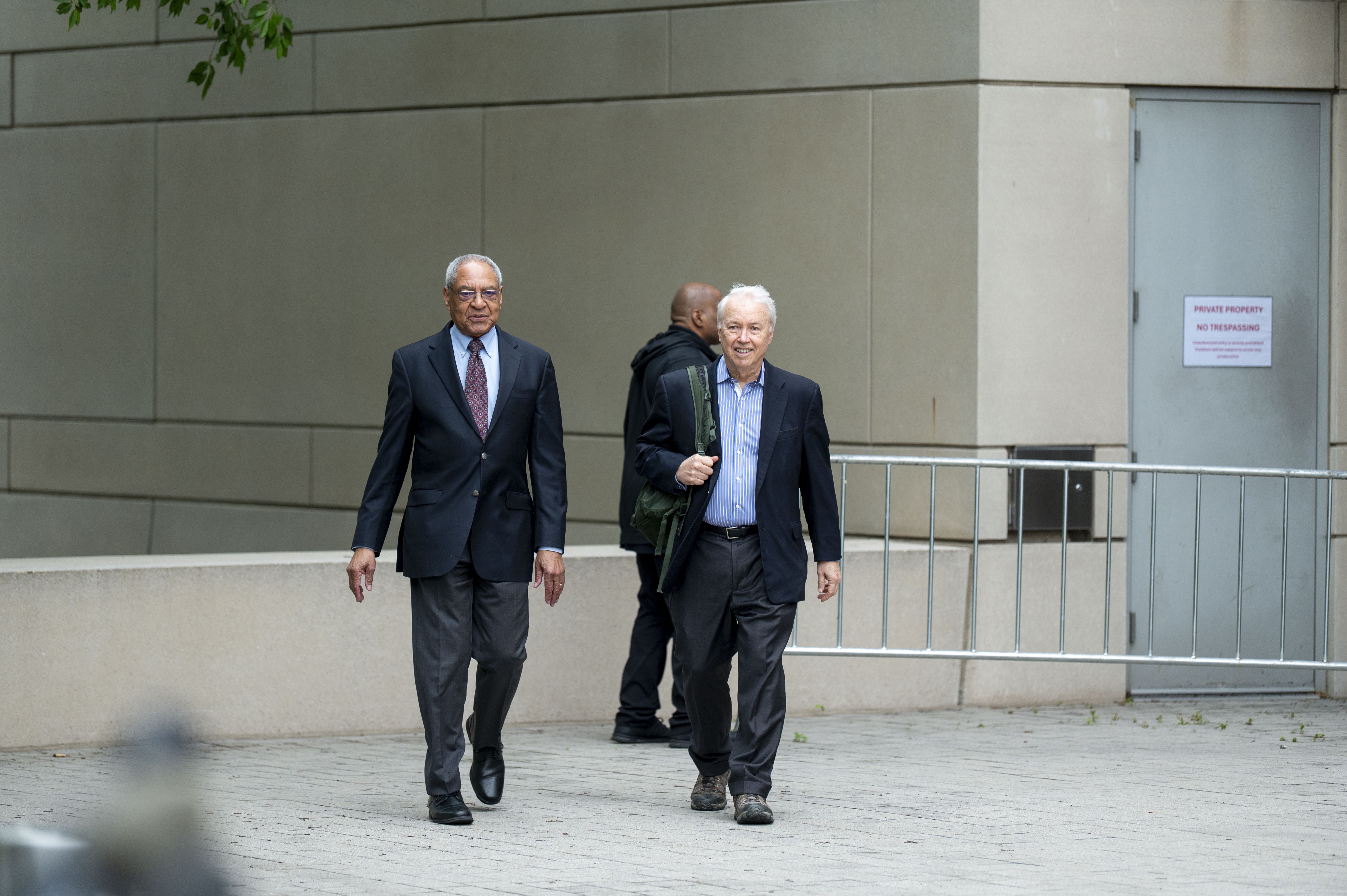 U.S. Institute of Peace (USIP) acting President George Moose, left, and USIP acting counsel George Foote walk out of the Institute to talk to reporters, Wednesday, May 21, 2025 in Washington. (AP Photo/Kevin Wolf)