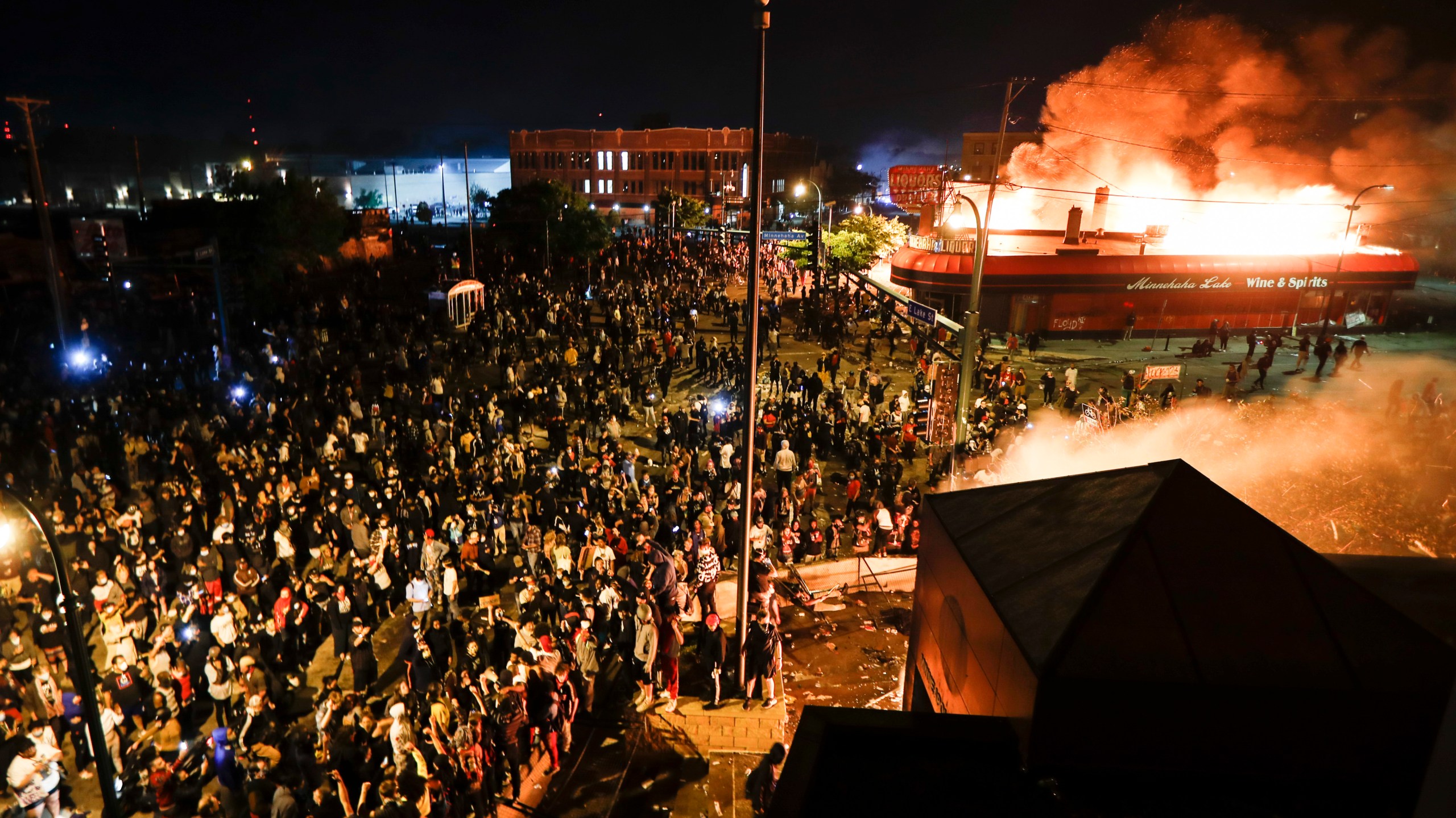 FILE - Protestors demonstrate outside of the burning Minneapolis 3rd Police Precinct in Minneapolis on May 28, 2020. (AP Photo/John Minchillo, File)