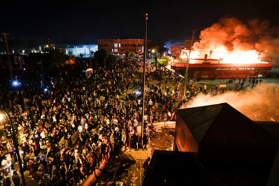 FILE - Protestors demonstrate outside of the burning Minneapolis 3rd Police Precinct in Minneapolis on May 28, 2020. (AP Photo/John Minchillo, File)
