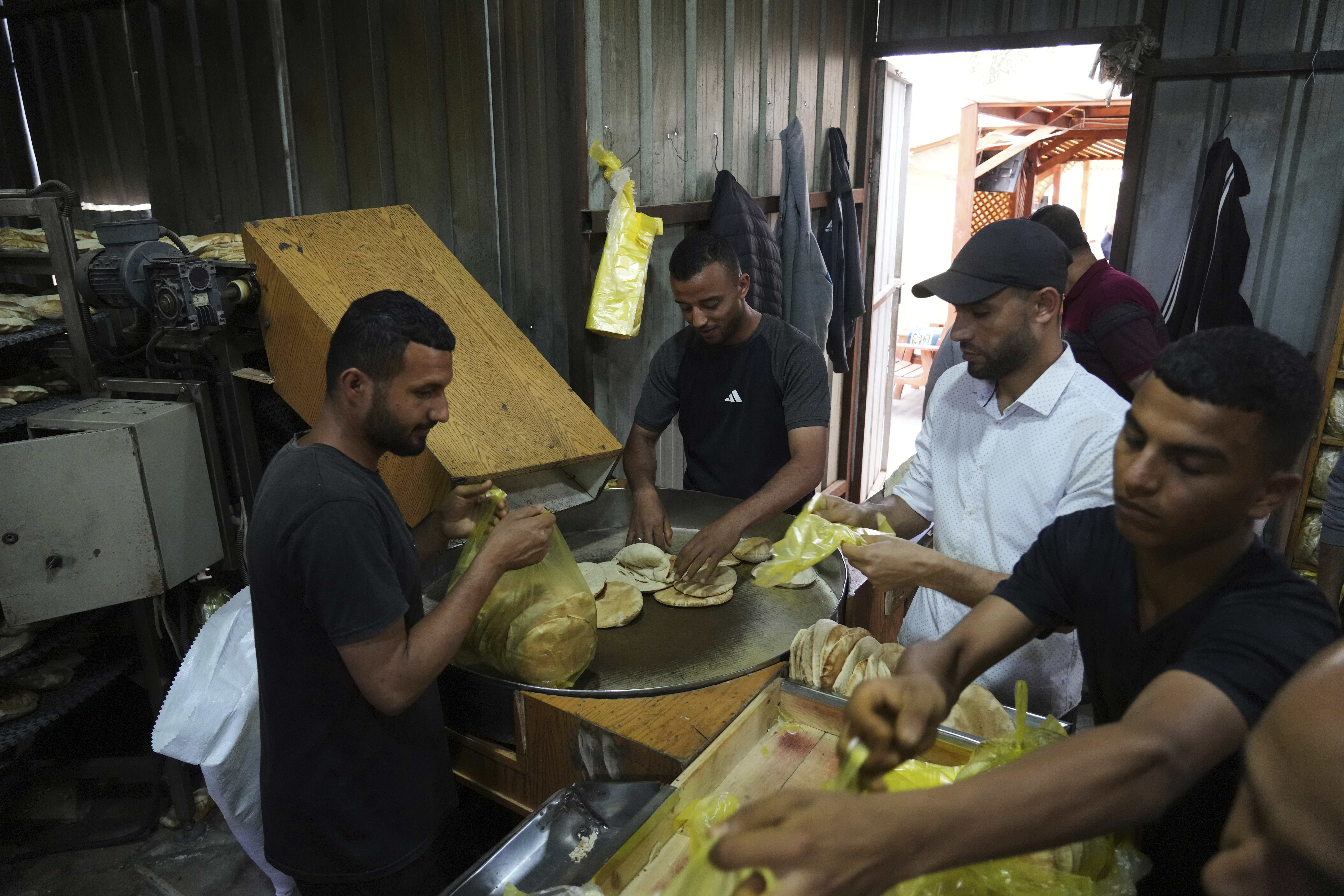Palestinians bake bread after the World Food Program was able to bring in flour for the first time in over a month as Israel allowed some aid to enter the Gaza Strip, in Deir al-Balah, Gaza Strip, Thursday, May 22, 2025. (AP Photo/Abdel Kareem Hana)