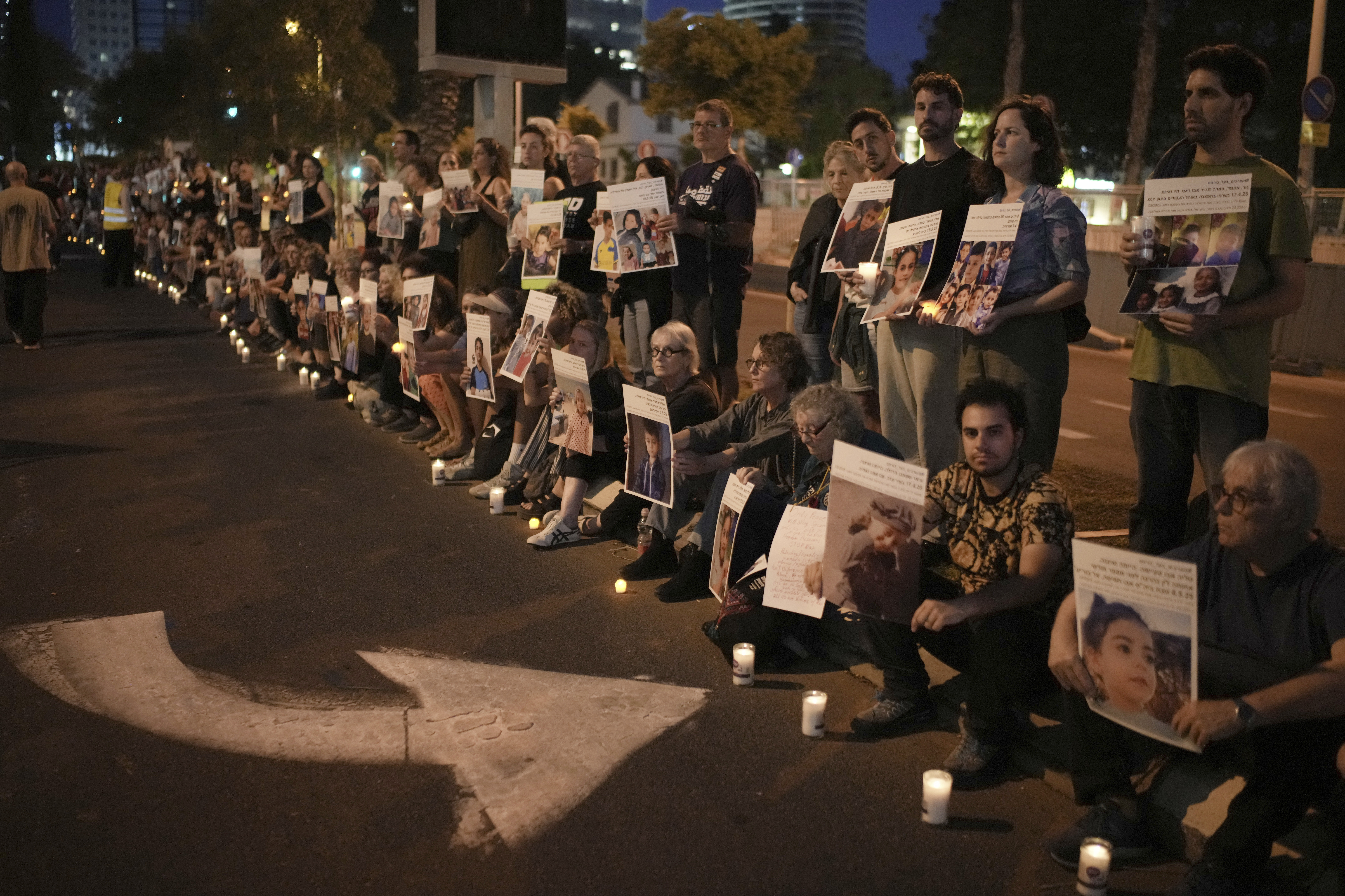 Israeli activists hold photos of Palestinian children killed during the Israel air and ground operation in the Gaza Strip, calling for an end to the war, during a protest in Tel Aviv, Israel, Saturday, May 24, 2025. (AP Photo/Leo Correa)