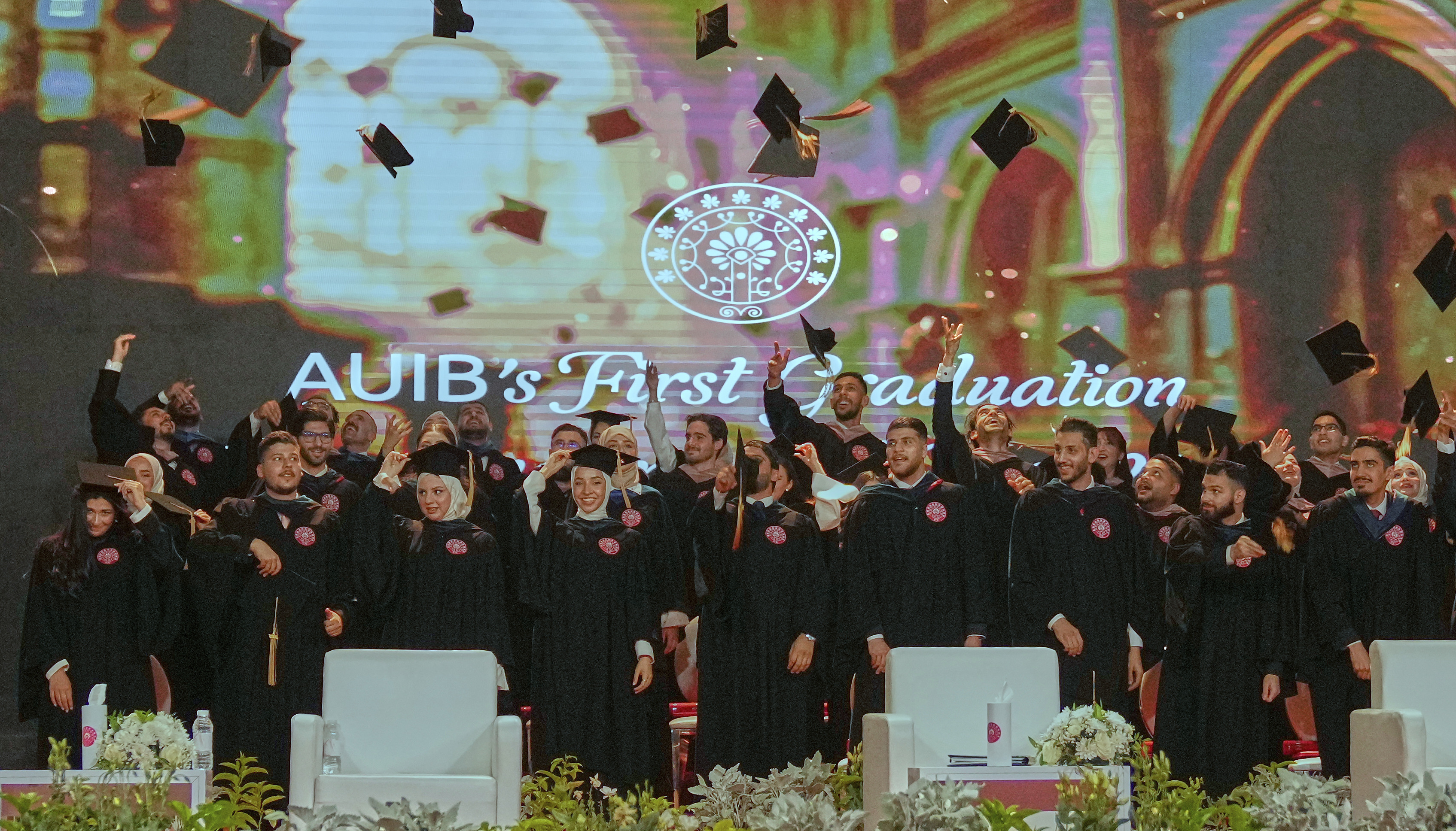 The American University of Iraq - Baghdad graduates throw their mortarboards into the air during the first graduation for the school in Baghdad, Iraq, Saturday, May 24, 2025. (AP Photo/Hadi Mizban)