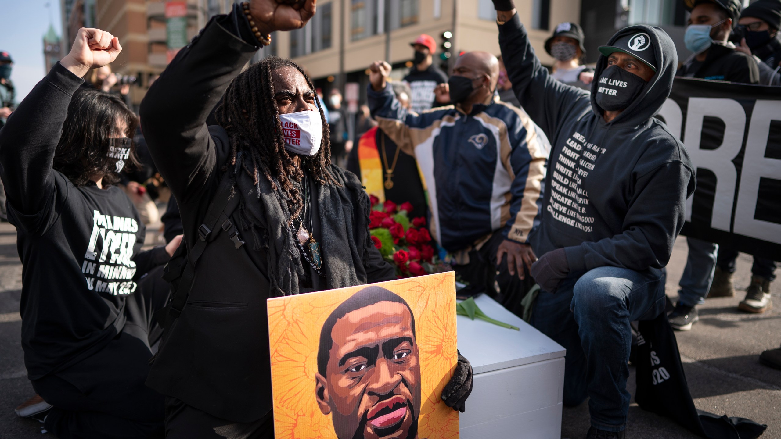 FILE - Cortez Rice, left, of Minneapolis, sits with others in the middle of Hennepin Avenue on Sunday, March 7, 2021, in Minneapolis, Minn., to mourn the death of George Floyd a day before jury selection is set to begin in the trial of former Minneapolis officer Derek Chauvin, who is accused of killing Floyd. (Jerry Holt /Star Tribune via AP, file)