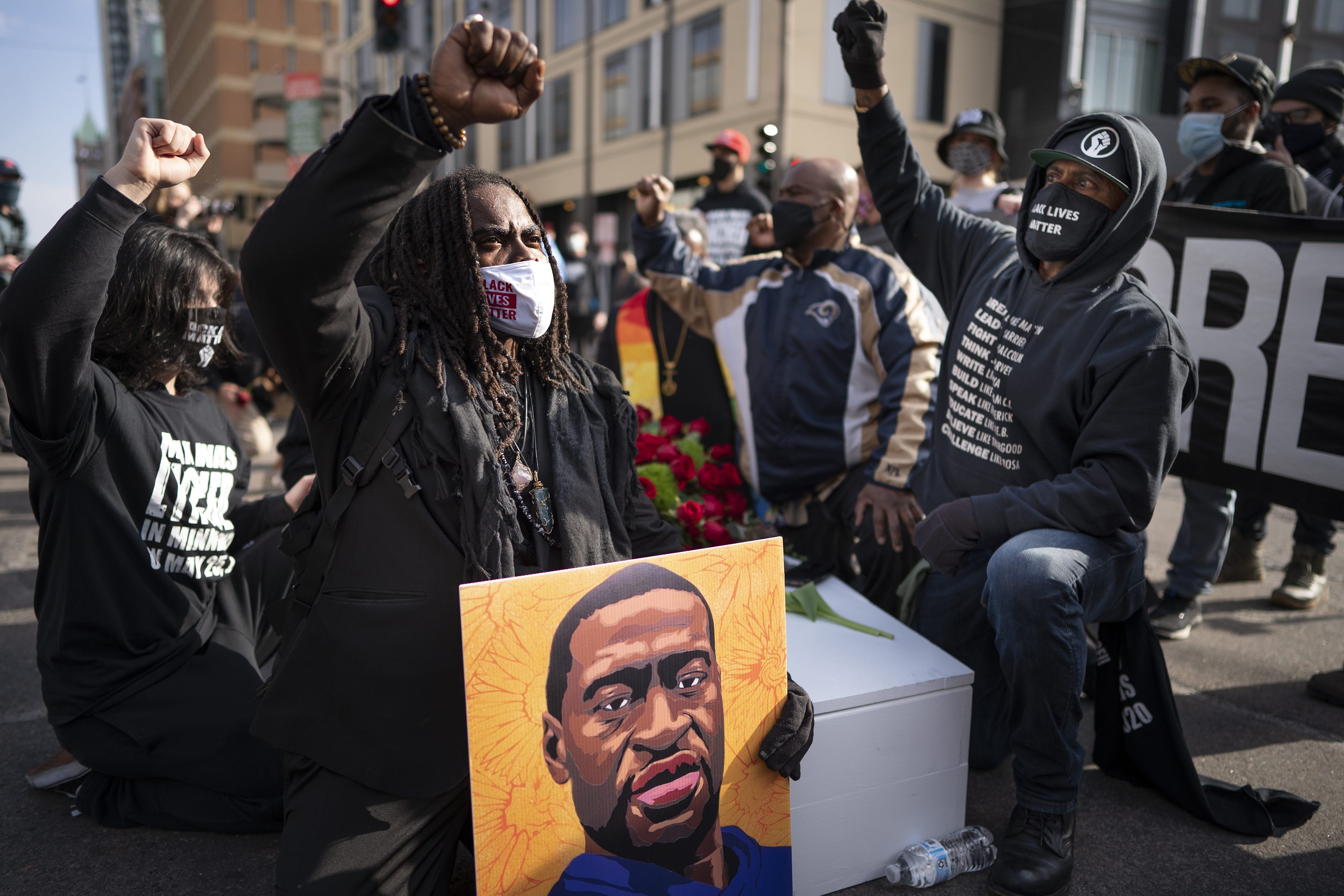 FILE - Cortez Rice, left, of Minneapolis, sits with others in the middle of Hennepin Avenue on Sunday, March 7, 2021, in Minneapolis, Minn., to mourn the death of George Floyd a day before jury selection is set to begin in the trial of former Minneapolis officer Derek Chauvin, who is accused of killing Floyd. (Jerry Holt /Star Tribune via AP, file)