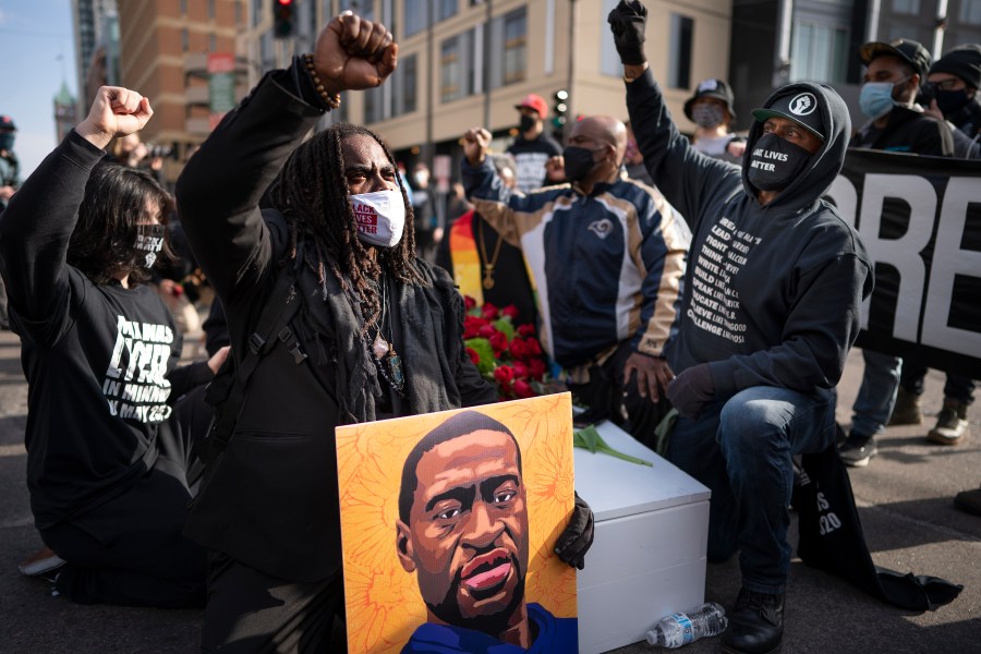 FILE - Cortez Rice, left, of Minneapolis, sits with others in the middle of Hennepin Avenue on Sunday, March 7, 2021, in Minneapolis, Minn., to mourn the death of George Floyd a day before jury selection is set to begin in the trial of former Minneapolis officer Derek Chauvin, who is accused of killing Floyd. (Jerry Holt /Star Tribune via AP, file)