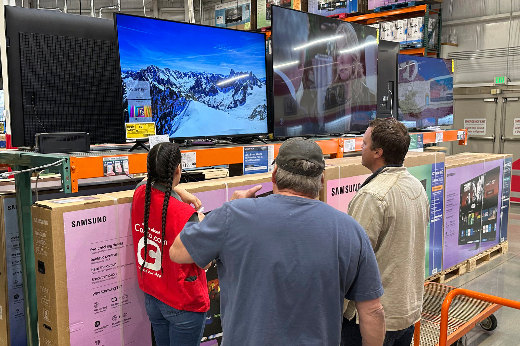 Shoppers consider a large-screen television with the help of a sales associate in a Costco warehouse Thursday, May 1, 2025, in Sheridan, Colo. (AP Photo/David Zalubowski)