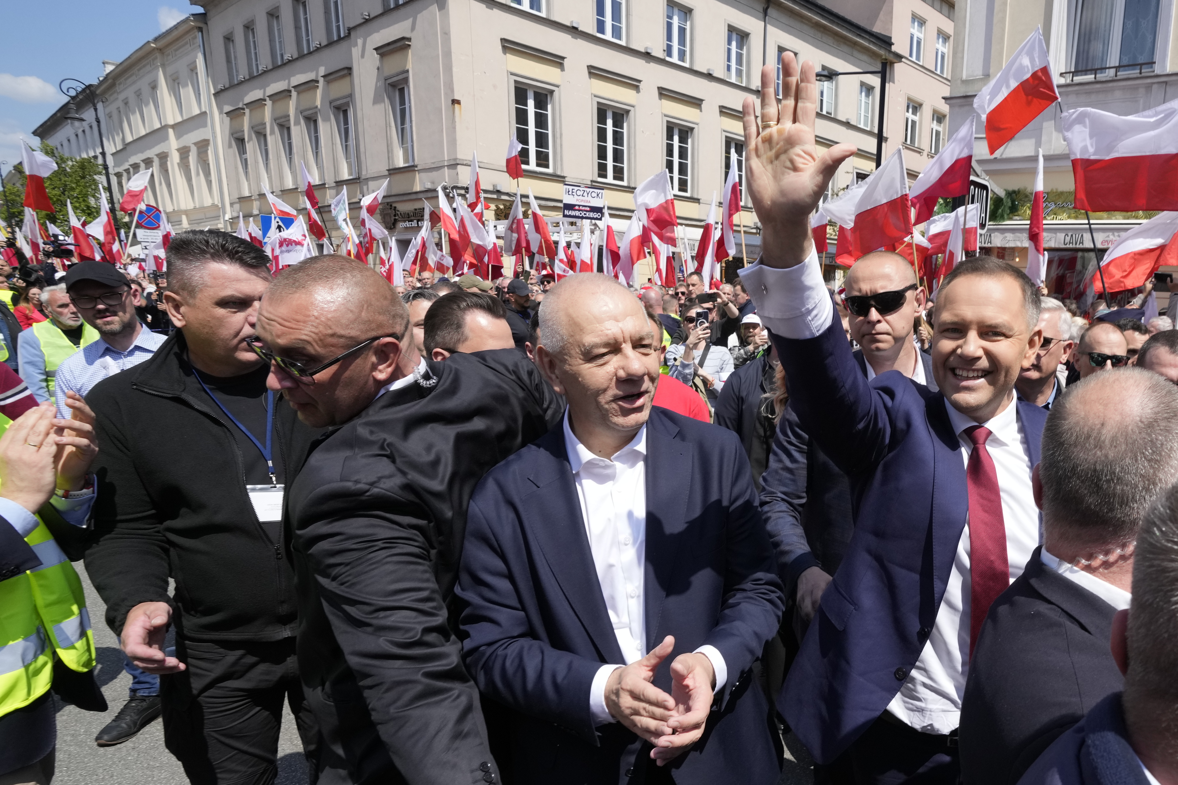 Conservative presidential candidate Karol Nawrocki, right, waves as he takes part in a march one week ahead of a decisive election in Warsaw Poland on Sunday, May 25, 2025. (AP Photo/Czarek Sokolowski)