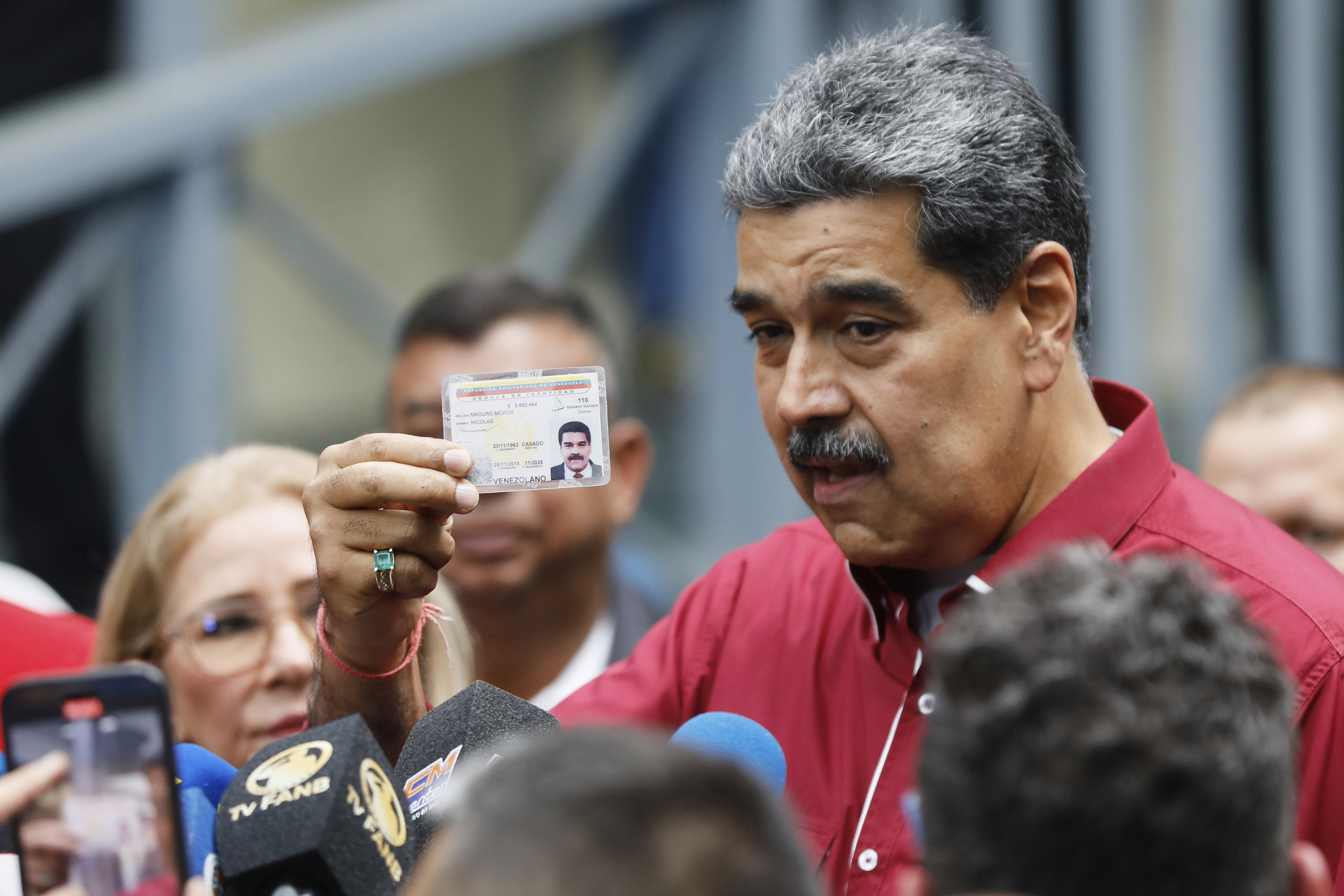 Venezuela's President Nicolas Maduro shows his ID to journalists after voting in legislative and local elections in Caracas, Venezuela, Sunday, May 25, 2025. (AP Photo/Cristian Hernandez)