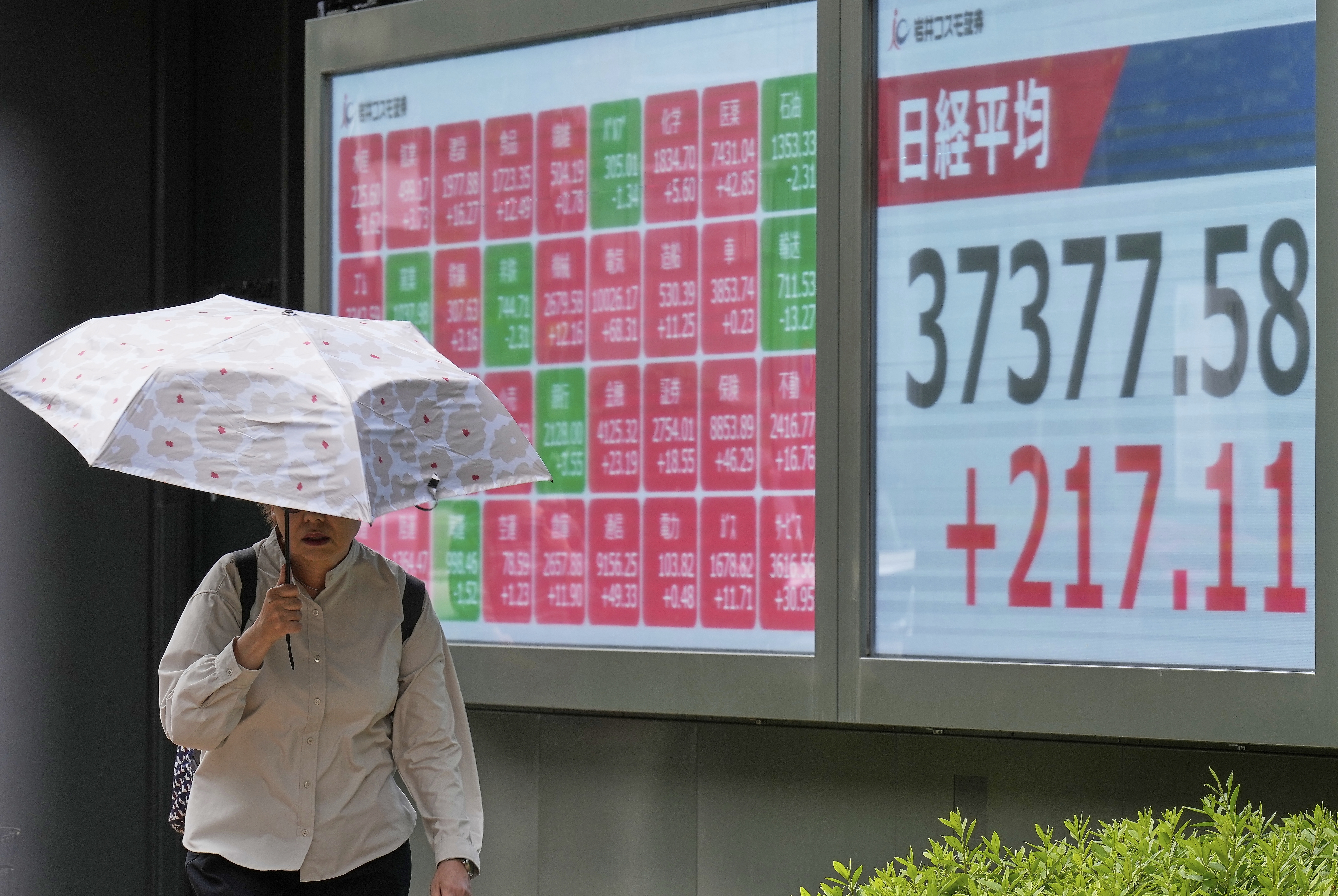A person walks in front of an electronic stock board showing Japan's Nikkei index at a securities firm Monday, May 26, 2025, in Tokyo. (AP Photo/Eugene Hoshiko)