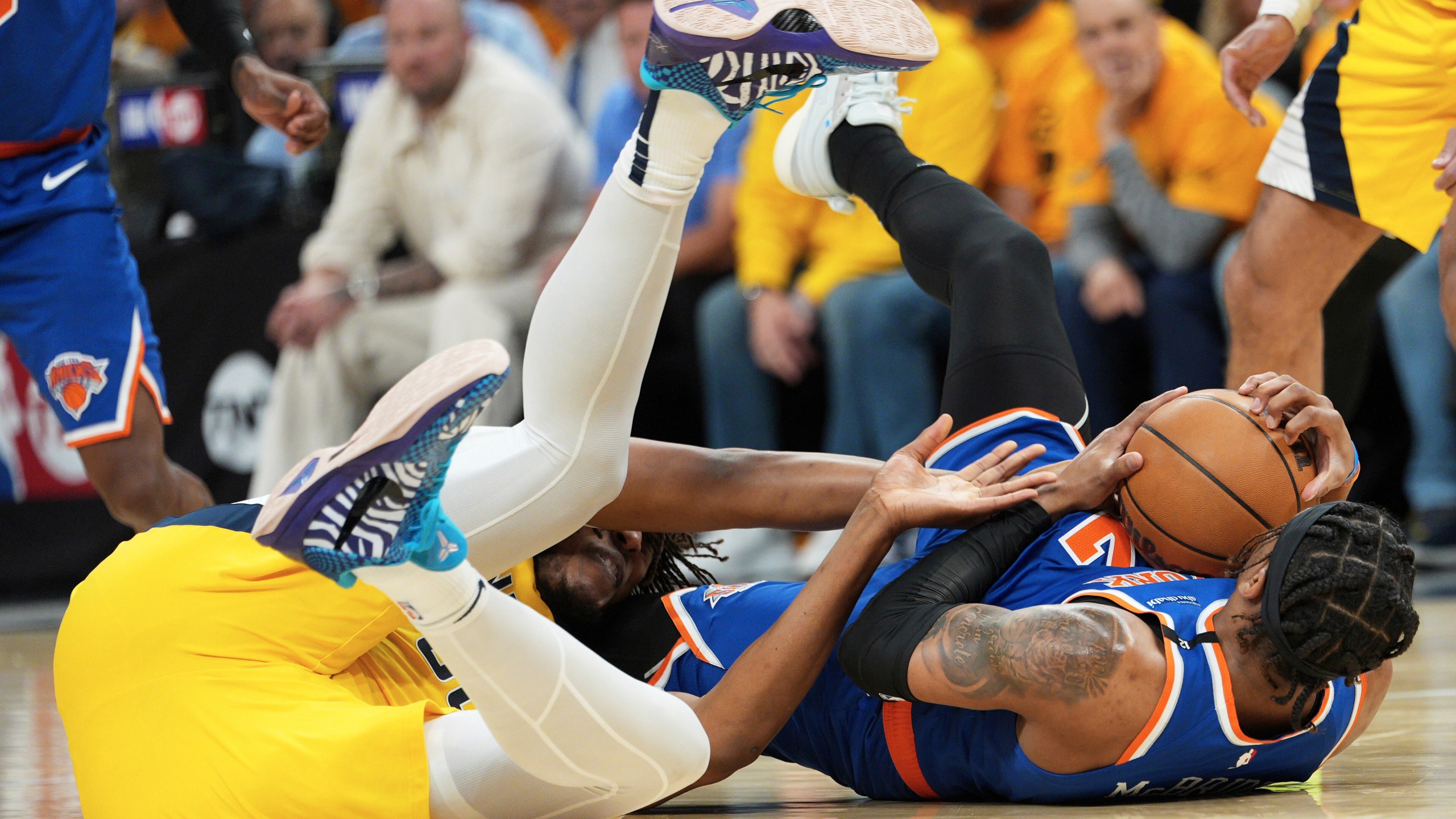 New York Knicks guard Miles McBride, right, tries to control the ball next to Indiana Pacers center Myles Turner during the second half of Game 3 of the Eastern Conference finals of the NBA basketball playoffs Sunday, May 25, 2025, in Indianapolis. (AP Photo/AJ Mast)