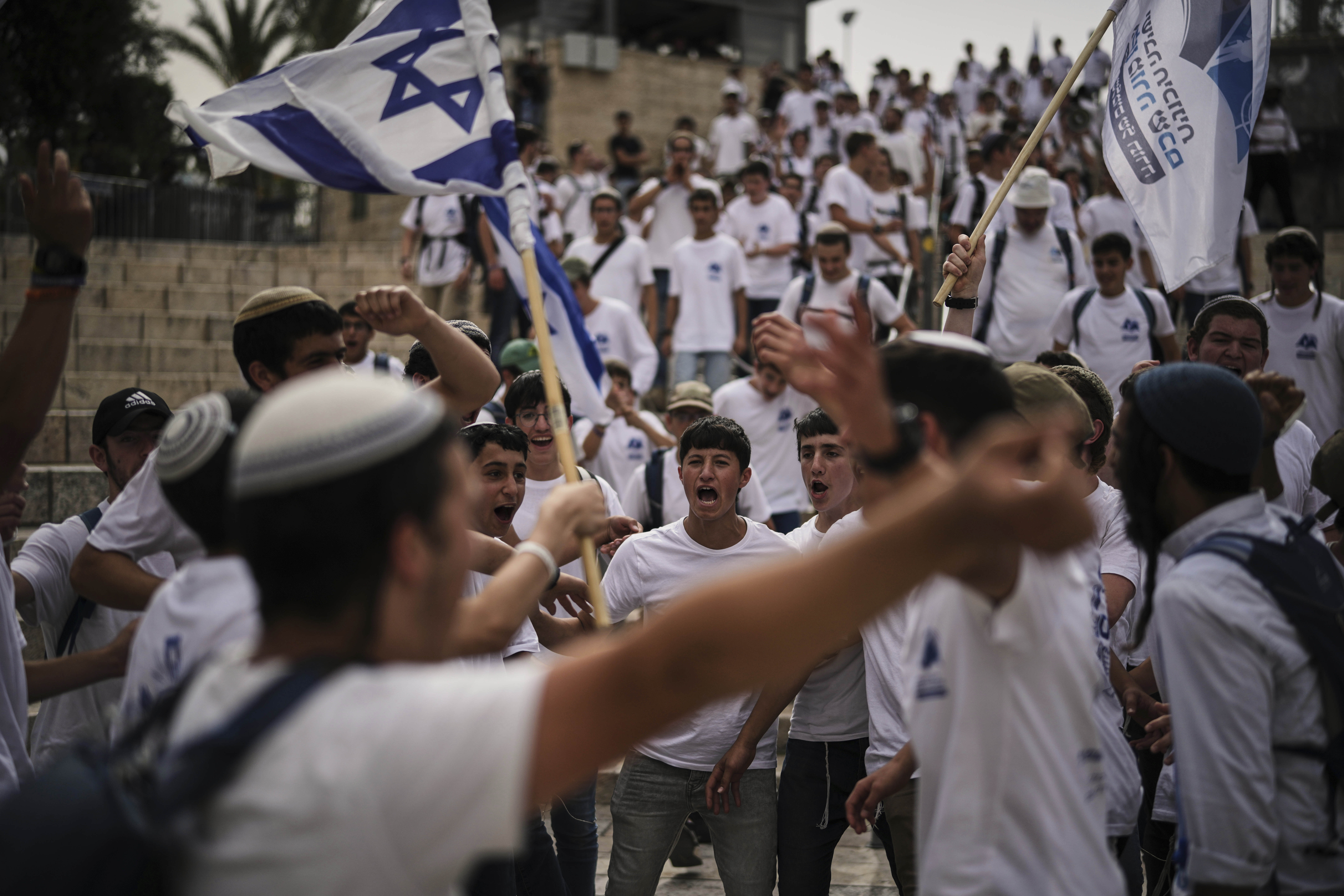 Israelis wave national flags during a march marking Jerusalem Day, an Israeli holiday celebrating the capture of east Jerusalem in the 1967 Mideast war, in Jerusalem's Old City, Monday, May 26, 2025. (AP Photo/Leo Correa)
