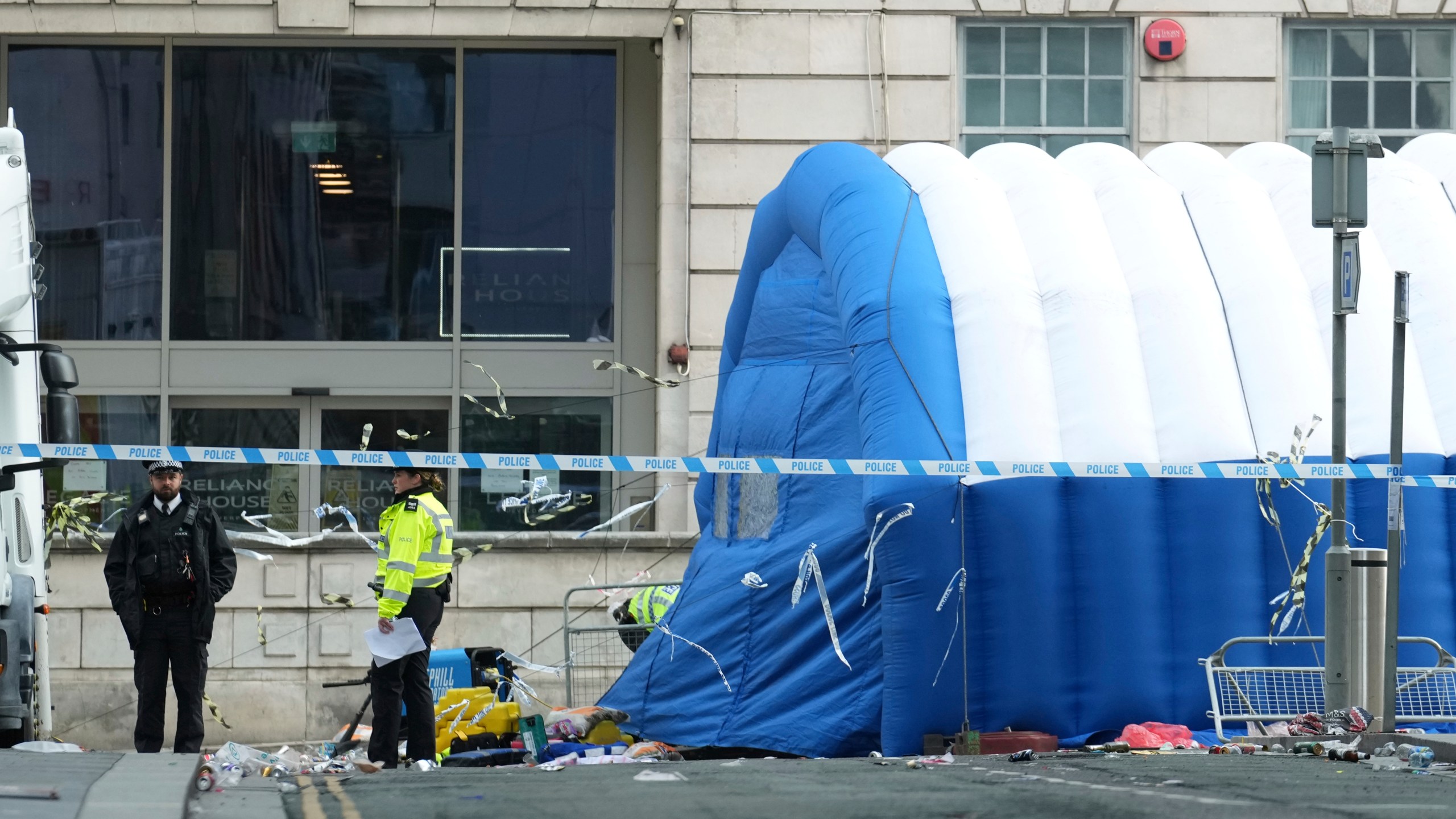 Police officers examine the road after a car collided with pedestrians near the Liver Building during yesterday's Premier League winners parade in Liverpool, England, Tuesday, May 27, 2025.(AP Photo/Jon Super)