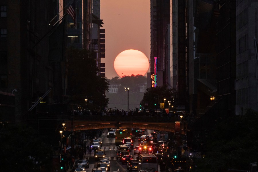 FILE - The sun sets as seen between buildings along 42nd Street in New York, May 30, 2023. (AP Photo/Yuki Iwamura, file)