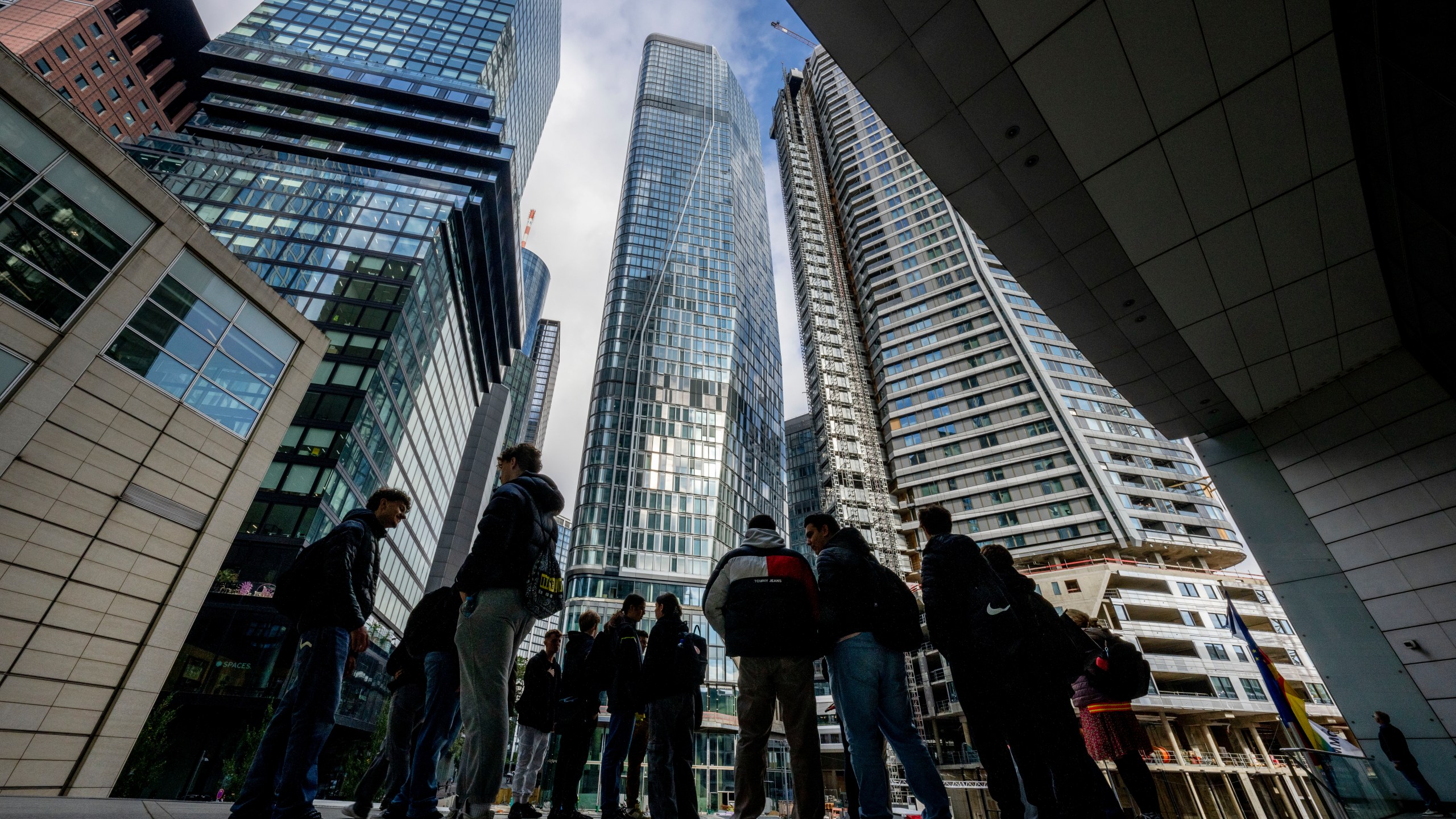 FILE - People stand in front of the city's largest construction site with four new high-rise buildings in Frankfurt, Germany, Sept. 24, 2024. (AP Photo/Michael Probst, file)