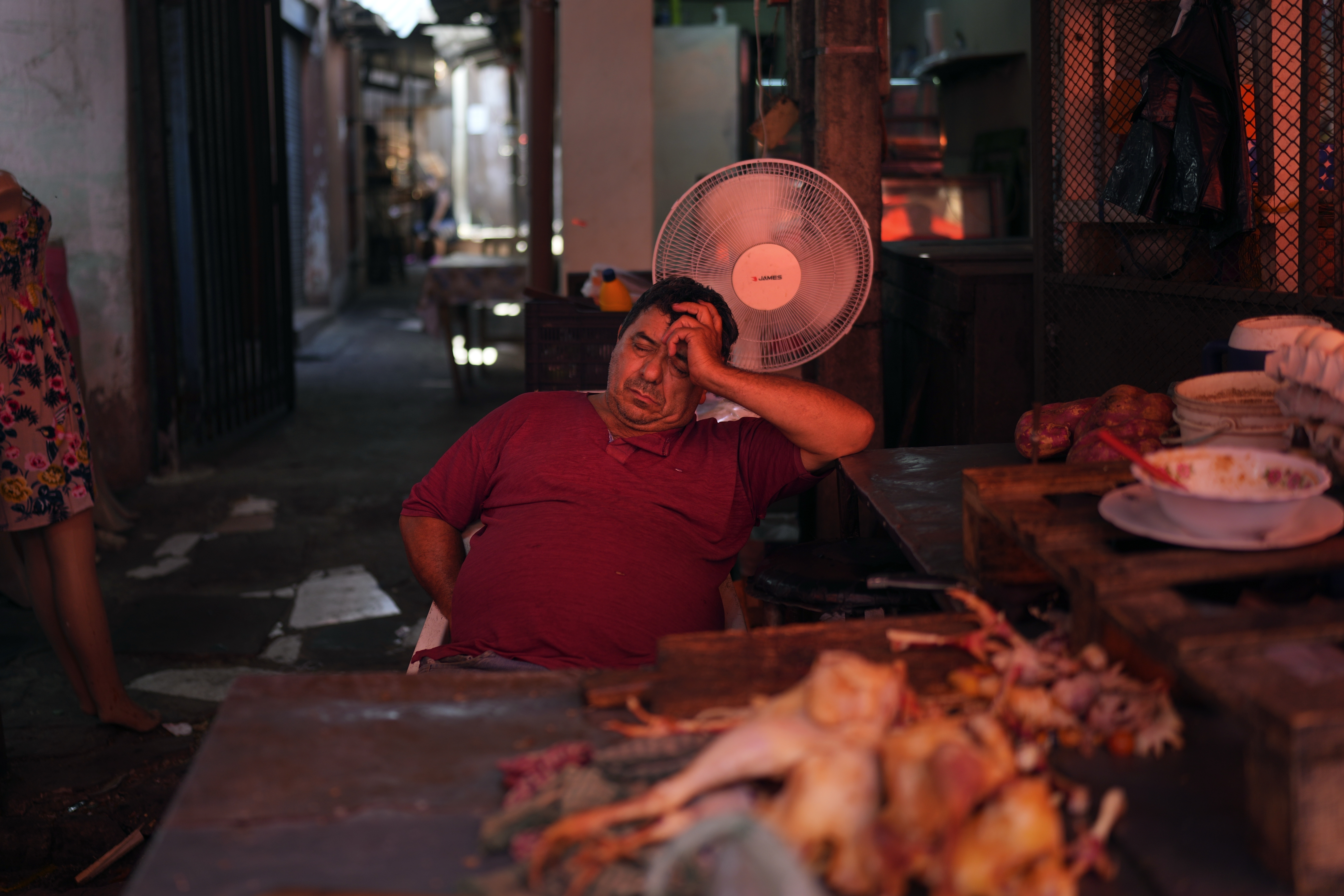 FILE - A vendor sleeps near a fan on a hot afternoon at his shop at Market 4 in Asuncion, Paraguay, Jan. 17, 2025. (AP Photo/Jorge Saenz, File)