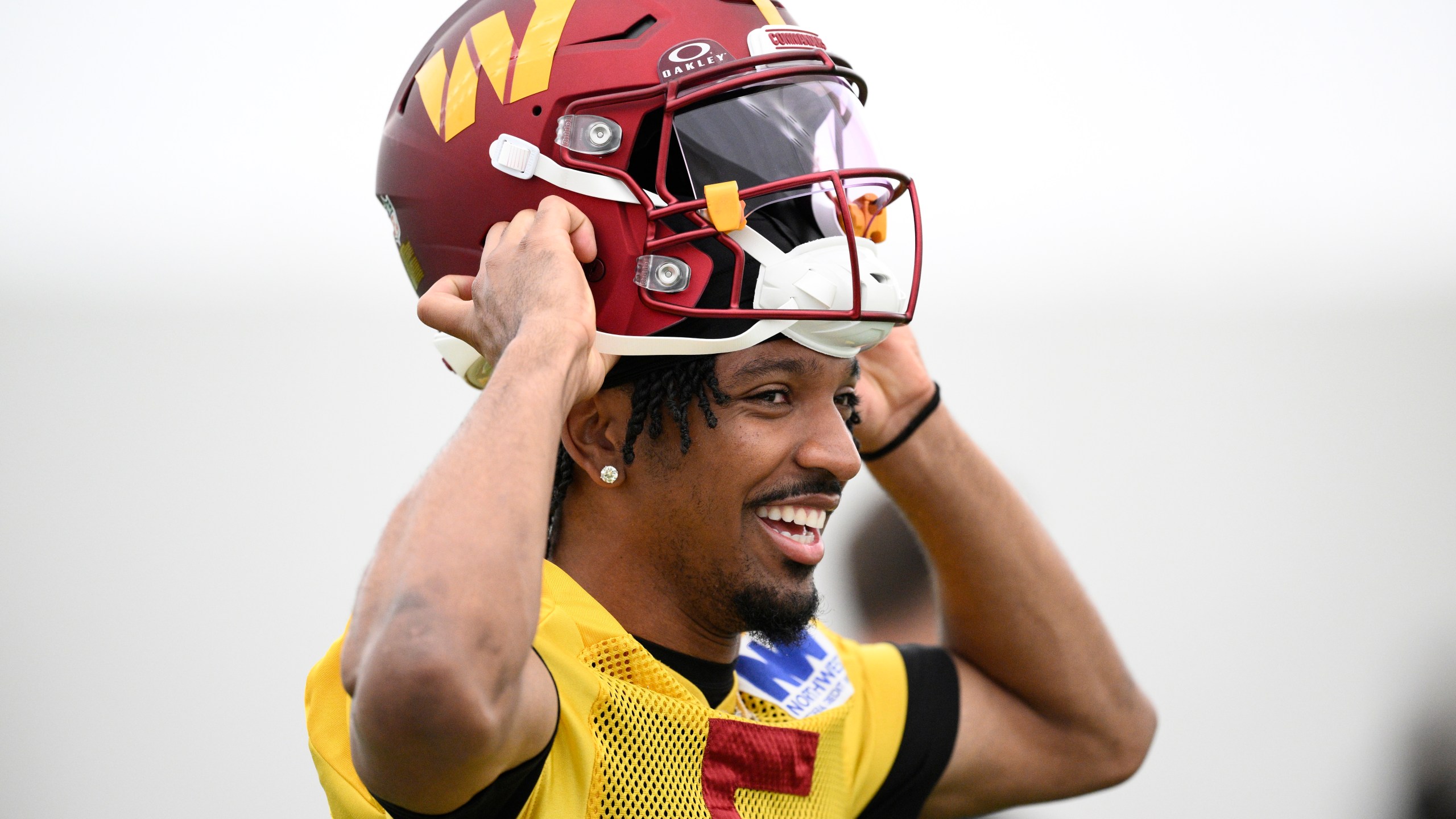 Washington Commanders quarterback Jayden Daniels puts on his helmet during NFL football practice, Wednesday, May 28, 2025, in Ashburn, Va. (AP Photo/Nick Wass)
