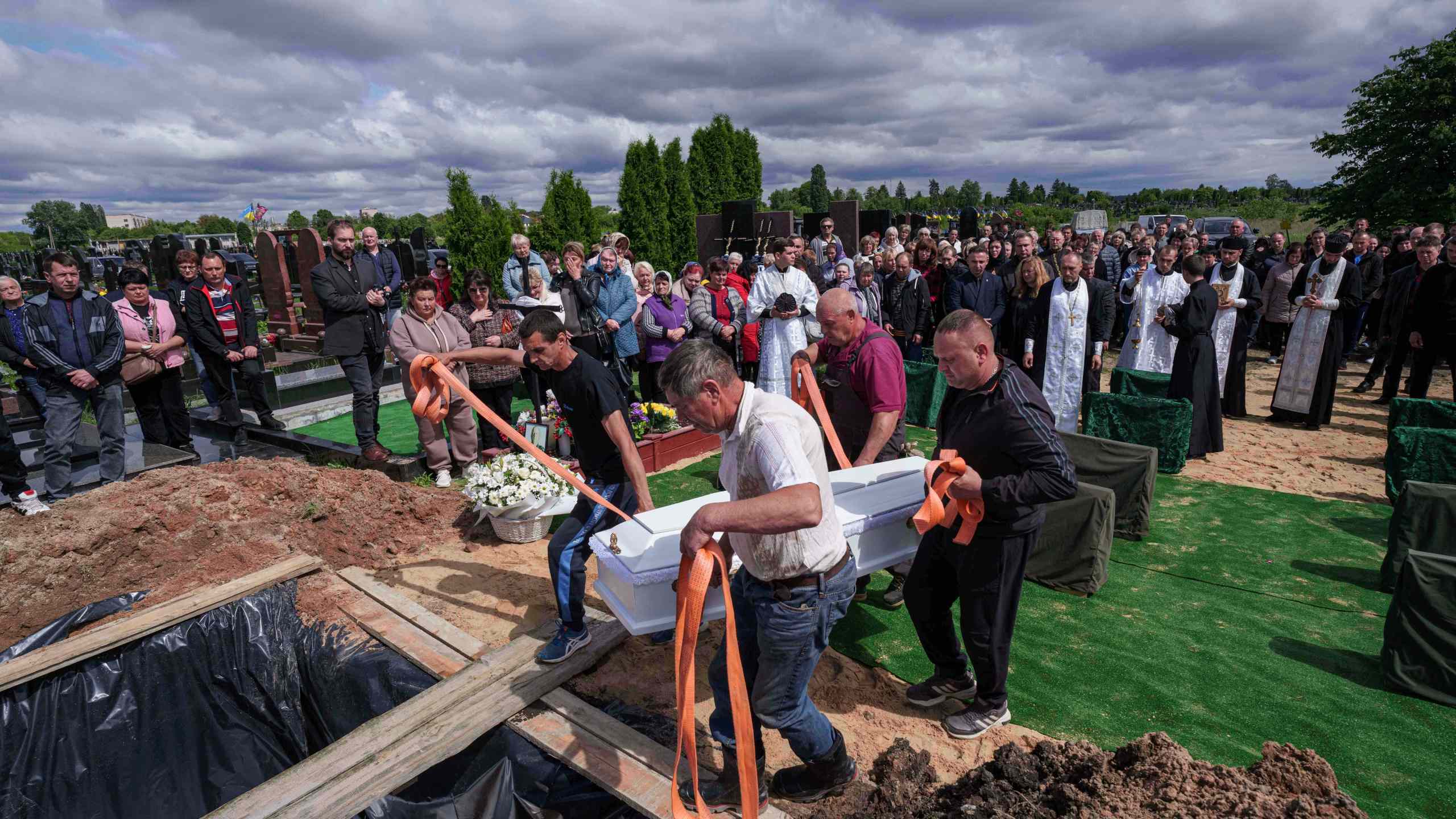 Funeral workers carry the coffin of Tamara Martyniuk, 8, killed in a Russian strike on Sunday together with Stanislav Martyniuk, 12, and Roman Martyniuk, 17, during a funeral ceremony in Korostyshiv, Zhytomyr region, Ukraine, Wednesday, May 28, 2025. (AP Photo/Evgeniy Maloletka)