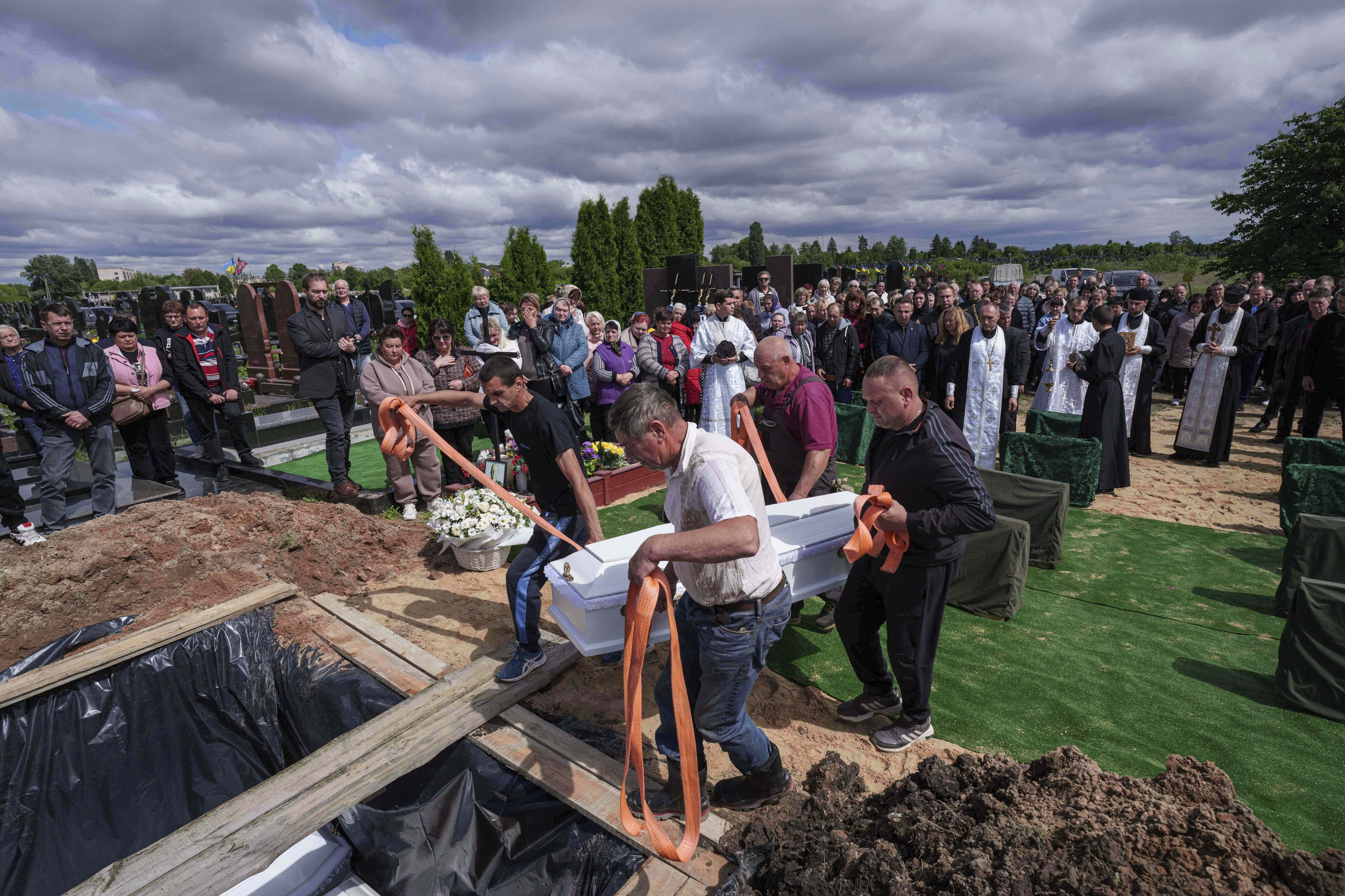 Funeral workers carry the coffin of Tamara Martyniuk, 8, killed in a Russian strike on Sunday together with Stanislav Martyniuk, 12, and Roman Martyniuk, 17, during a funeral ceremony in Korostyshiv, Zhytomyr region, Ukraine, Wednesday, May 28, 2025. (AP Photo/Evgeniy Maloletka)