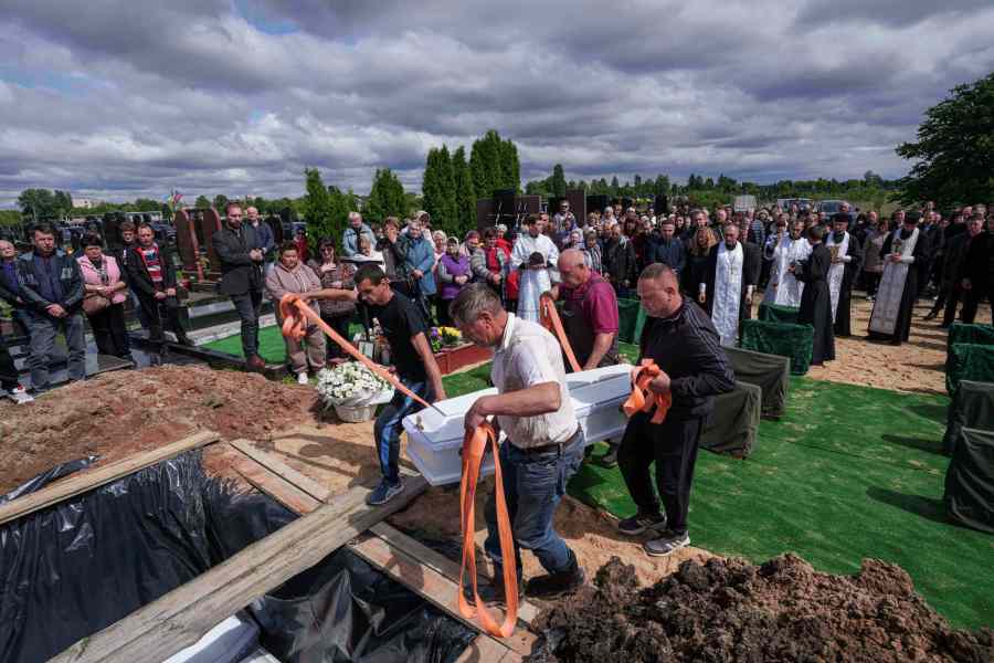 Funeral workers carry the coffin of Tamara Martyniuk, 8, killed in a Russian strike on Sunday together with Stanislav Martyniuk, 12, and Roman Martyniuk, 17, during a funeral ceremony in Korostyshiv, Zhytomyr region, Ukraine, Wednesday, May 28, 2025. (AP Photo/Evgeniy Maloletka)