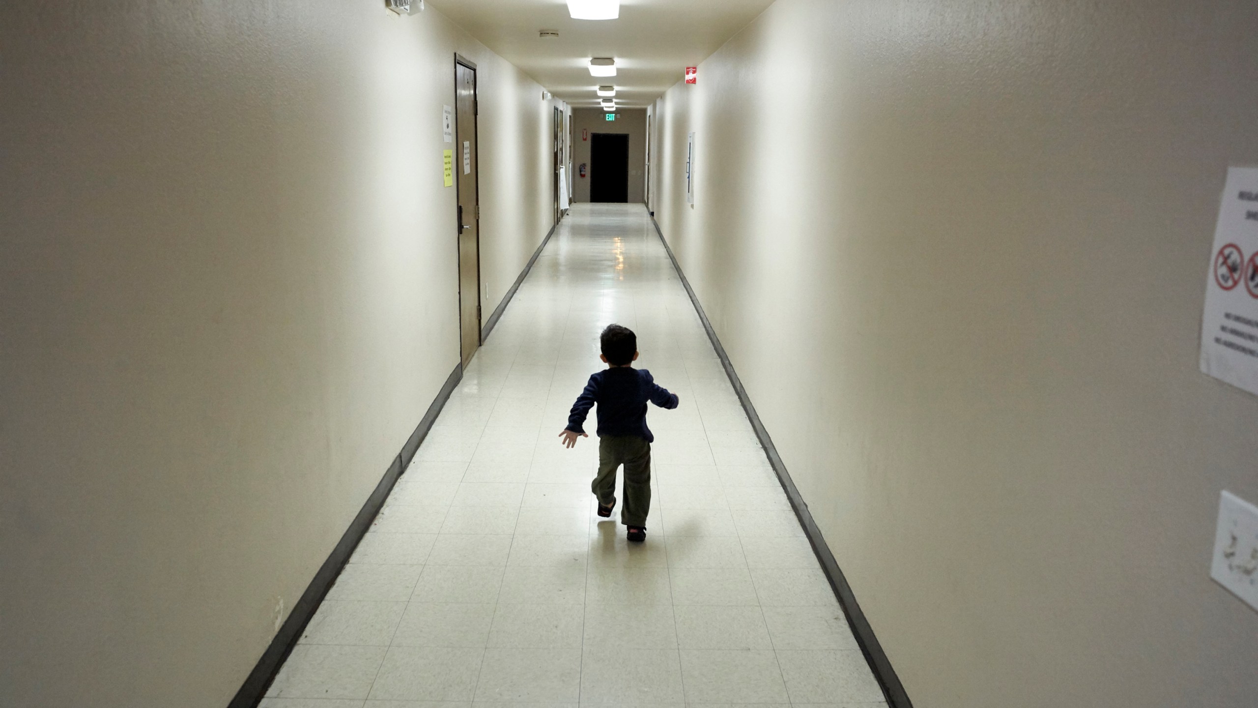 FILE - An asylum-seeking boy from Central America runs down a hallway after arriving from an immigration detention center to a shelter in San Diego, Dec. 11, 2018. (AP Photo/Gregory Bull, File)