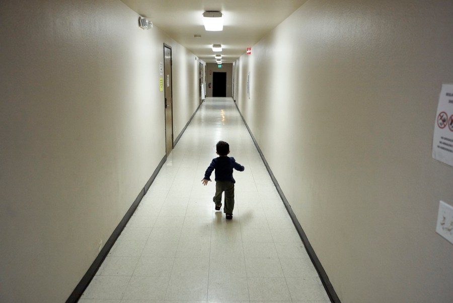 FILE - An asylum-seeking boy from Central America runs down a hallway after arriving from an immigration detention center to a shelter in San Diego, Dec. 11, 2018. (AP Photo/Gregory Bull, File)