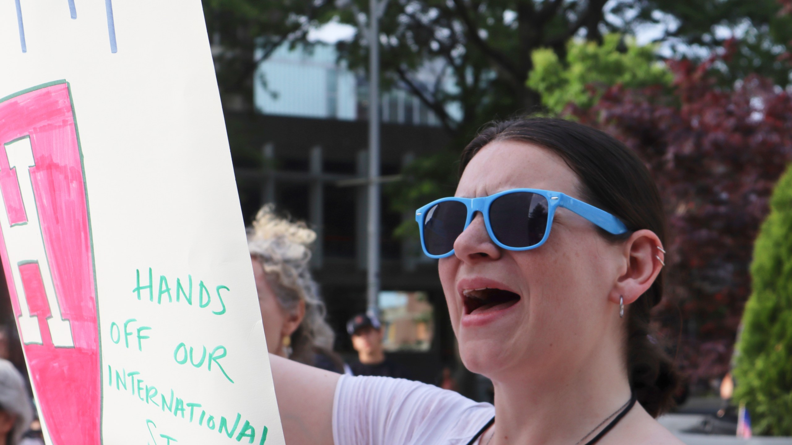 A protester cheers while listening to Harvard University students speak at a protest against President Donald Trump's recent sanctions against Harvard in front of Science Center Plaza on Tuesday, May 27, 2025, in Cambridge, Mass. (AP Photo/Leah Willingham)