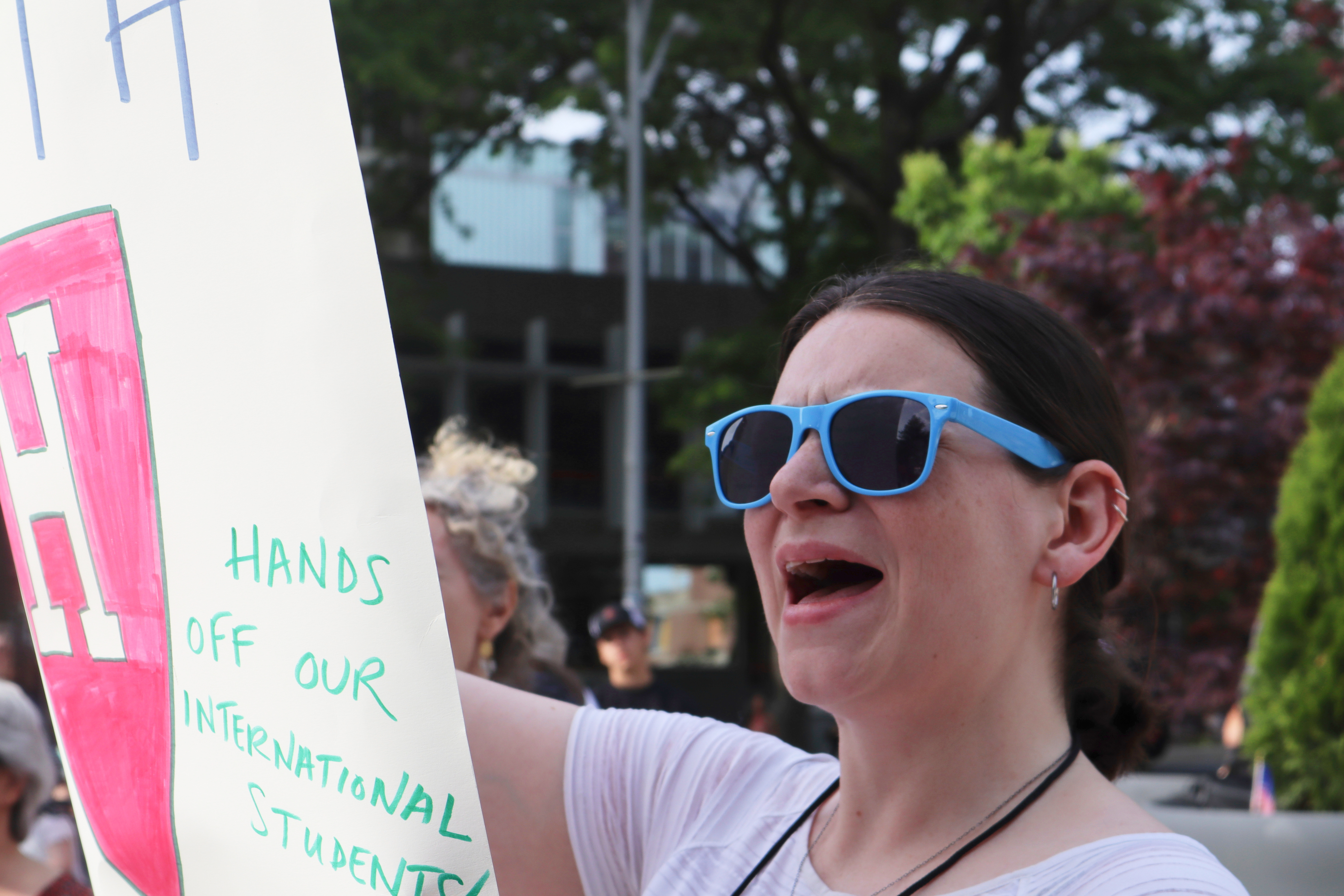 A protester cheers while listening to Harvard University students speak at a protest against President Donald Trump's recent sanctions against Harvard in front of Science Center Plaza on Tuesday, May 27, 2025, in Cambridge, Mass. (AP Photo/Leah Willingham)