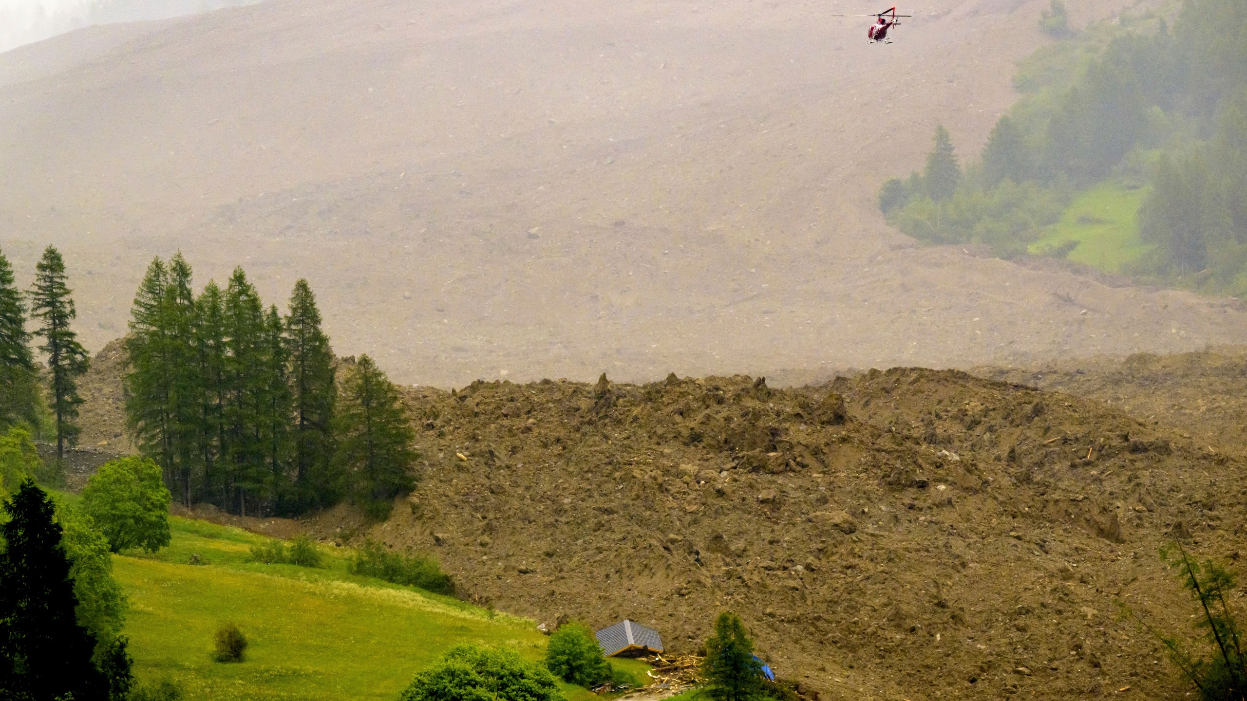A large avalanche with a mixture of ice, rock, snow and water reach the valley floor is pictured in Wiler after the Birch glacier collapsing above Blatten, Switzerland, Wednesday, May 28, 2025. (Jean-Christophe Bott/Keystone via AP)