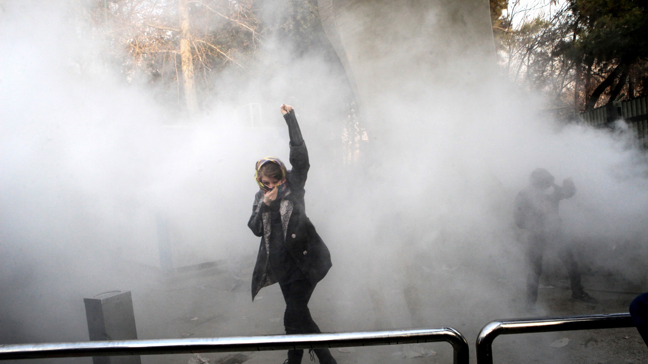 FILE - In this photo taken by a person not employed by the Associated Press and obtained by the AP outside Iran, a university student attends a protest inside Tehran University after a smoke grenade was thrown by anti-riot Iranian police, in Tehran, Iran, Dec. 30, 2017. (AP Photo, File)