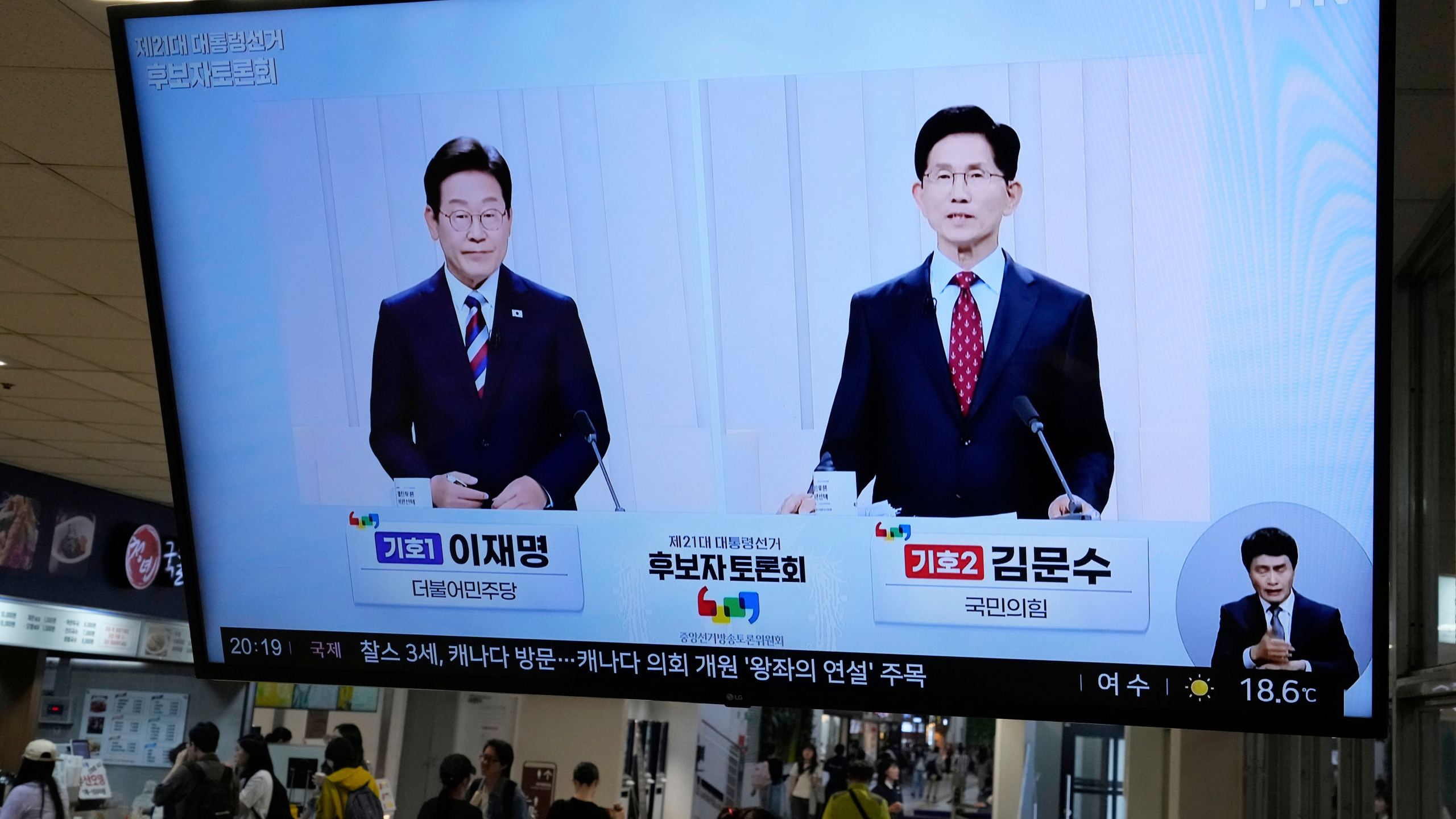FILE - A TV screen shows the People Power Party's presidential candidate Kim Moon Soo, right, and the Democratic Party's presidential candidate Lee Jae-myung during a presidential debate for the upcoming June 3 presidential election, at a bus terminal in Seoul, South Korea, on May 27, 2025. (AP Photo/Ahn Young-joon, File)