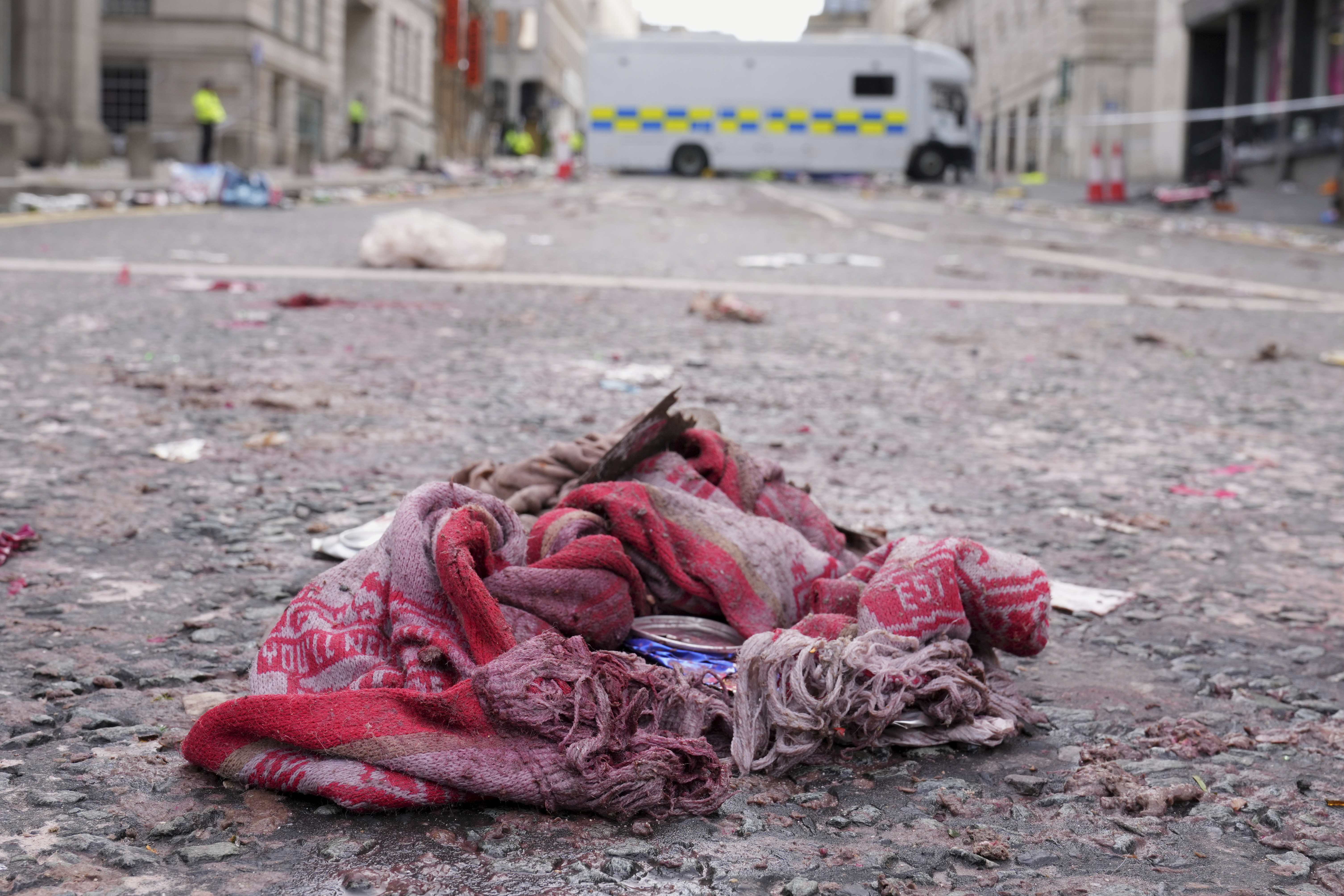 A fan scarf lies near the site where a 53-year-old British man plowed a minivan into a crowd of Liverpool soccer fans who were celebrating the city's Premier League championship Monday, injuring more than 45 people in Liverpool, England, Tuesday, May 27, 2025.(AP Photo/Jon Super)