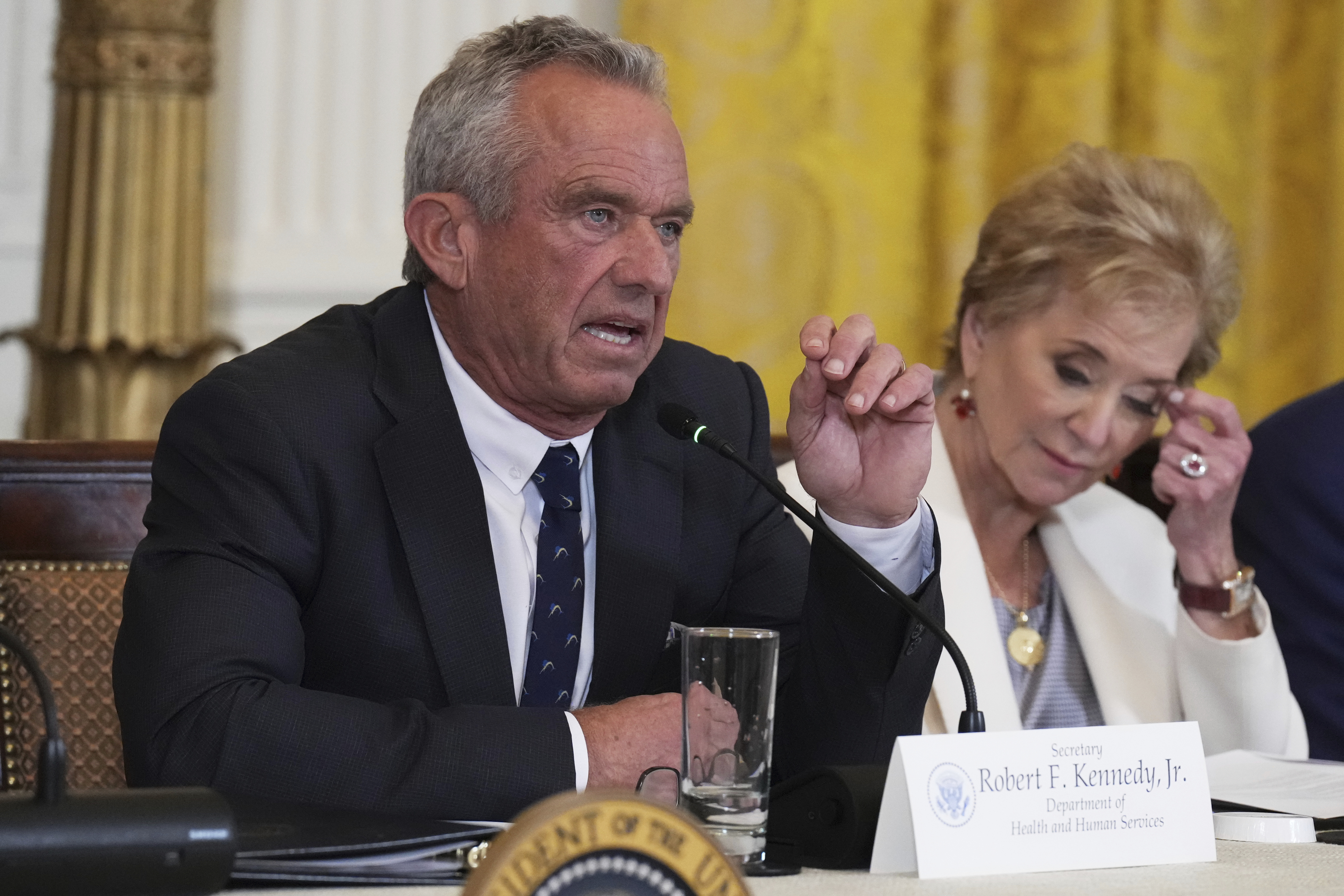Health and Human Services Secretary Robert F. Kennedy Jr. speaks as Education Secretary Linda McMahon listens during a Make America Healthy Again (MAHA) Commission Event in the East Room of the White House, Thursday, May 22, 2025, in Washington. (AP Photo/Jacquelyn Martin)