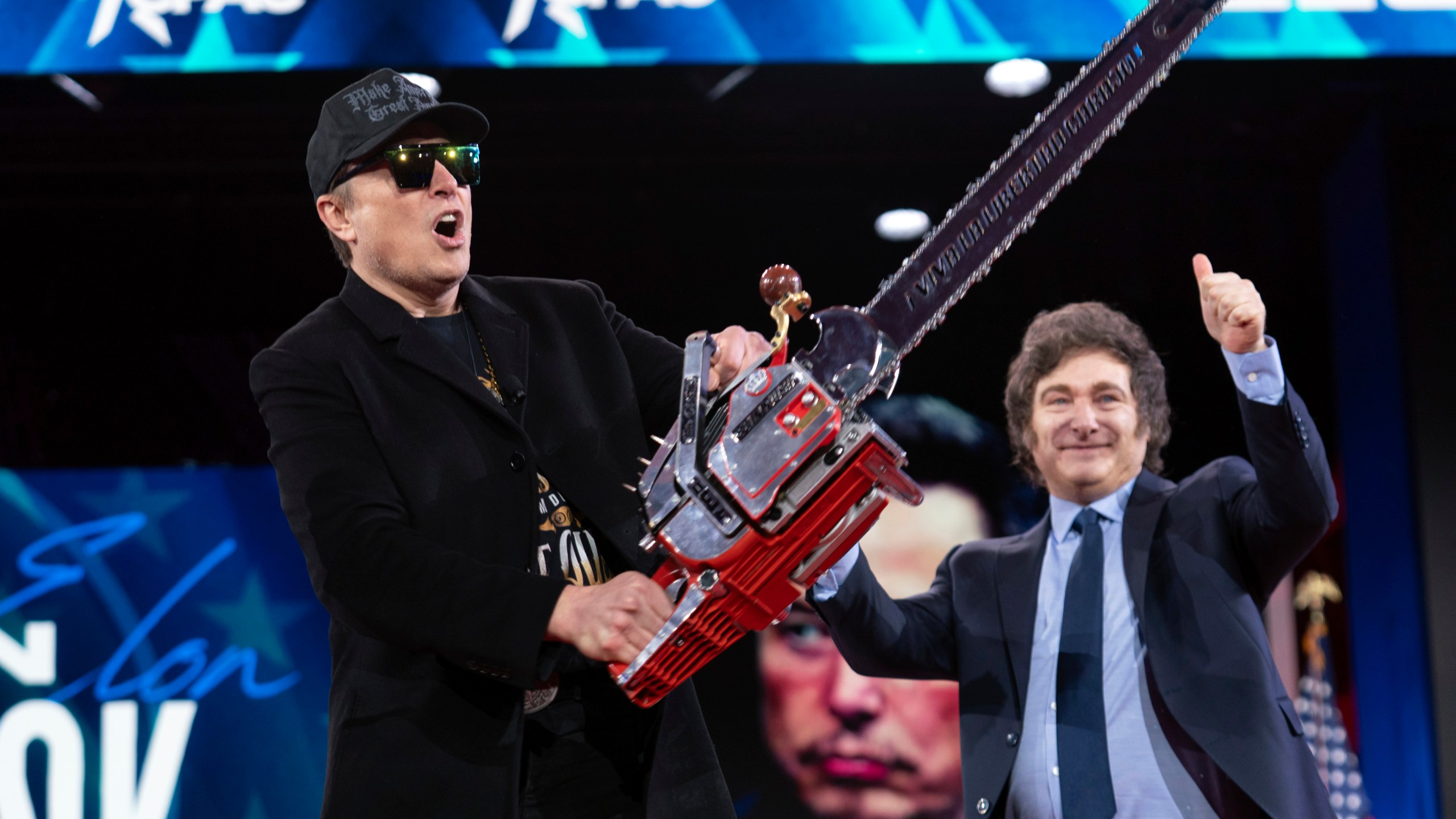 FILE - Elon Musk holds up a chainsaw he received from Argentina's President Javier Milei, right, as they arrive to speak at the Conservative Political Action Conference, CPAC, at the Gaylord National Resort & Convention Center, Feb. 20, 2025, in Oxon Hill, Md. (AP Photo/Jose Luis Magana, File)